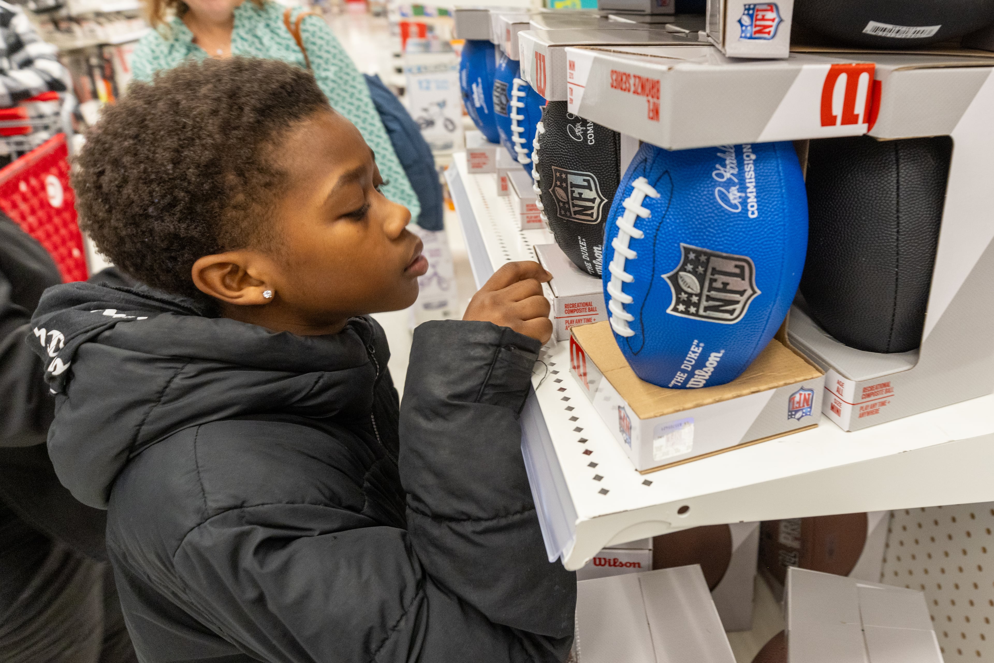 Kaleb Whidby, 9, contemplates a football during his Shop With The Sheriff event at the Target at Atlantic Station on Saturday, December 9, 2023. (Steve Schaefer/steve.schaefer@ajc.com)
