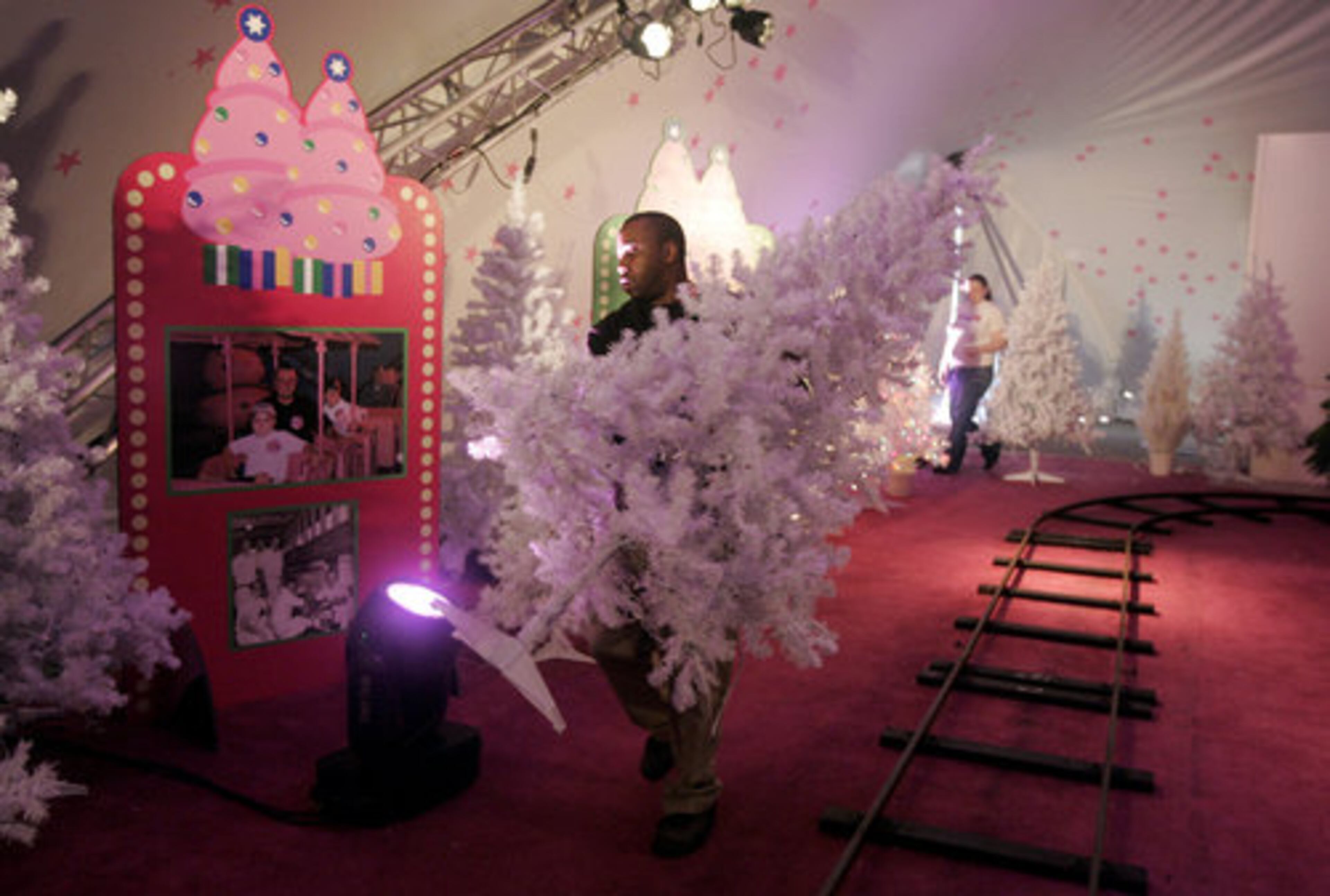 Alonzo Hand puts a Christmas tree in place as Nicole Therrien connects the wiring. For those who want to ride the Pink Pig, bring your imagination and $3.