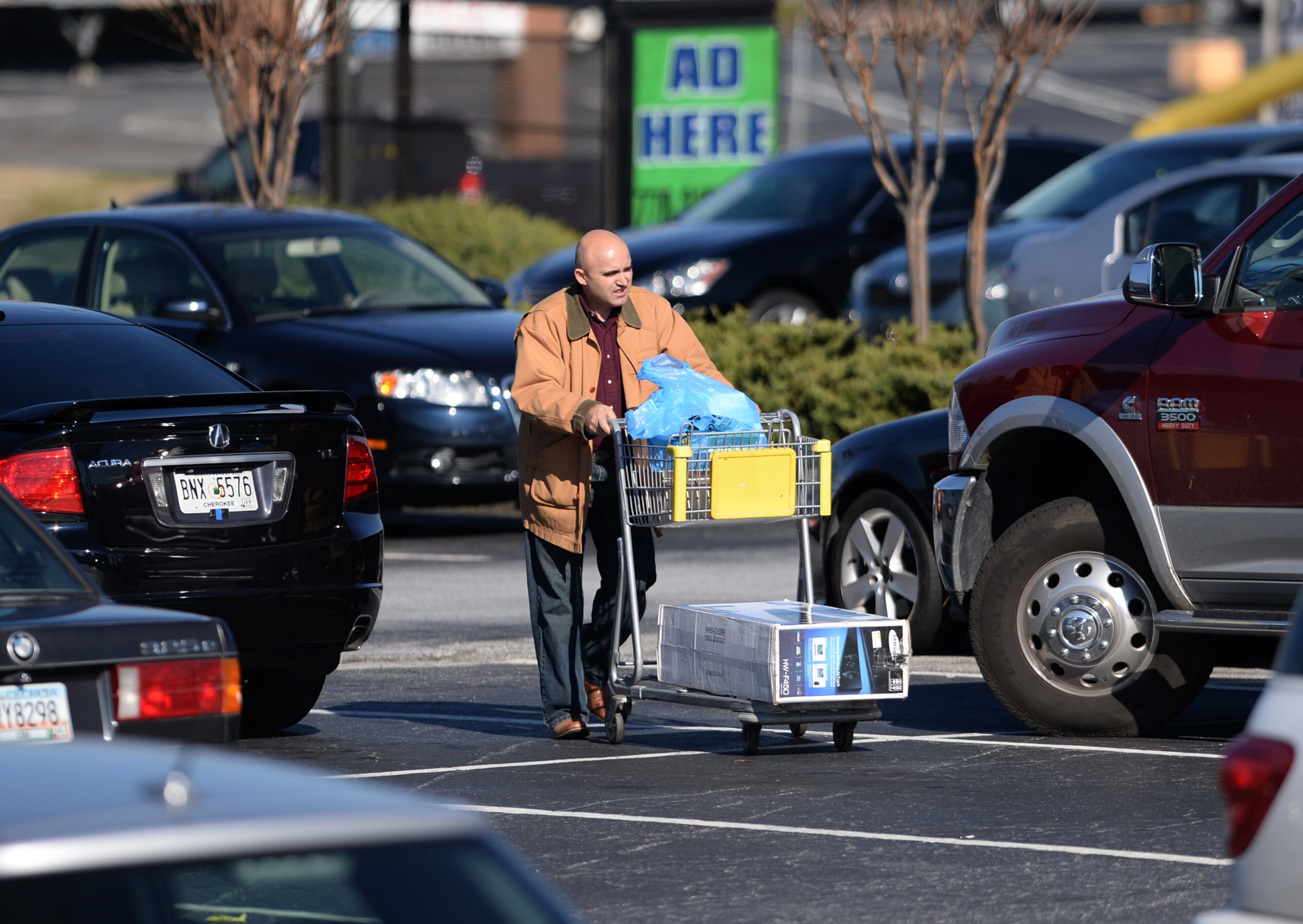 A shopper pushes a cart of items purchased from the Best Buy on Cobb Parkway on Tuesday, December 24, 2013. He was among the many last-minute Christmas shoppers on Christmas Eve.