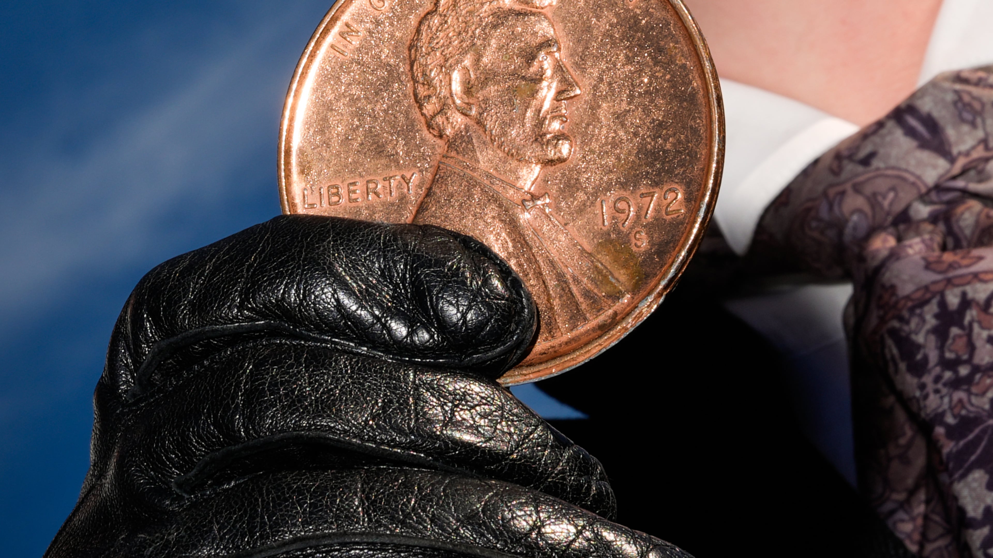 FILE - A person holds a giant penny at a mock funeral for the coin, Dec. 20, 2025, in front of the Lincoln Memorial in Washington. (AP Photo/Julia Demaree Nikhinson, File)