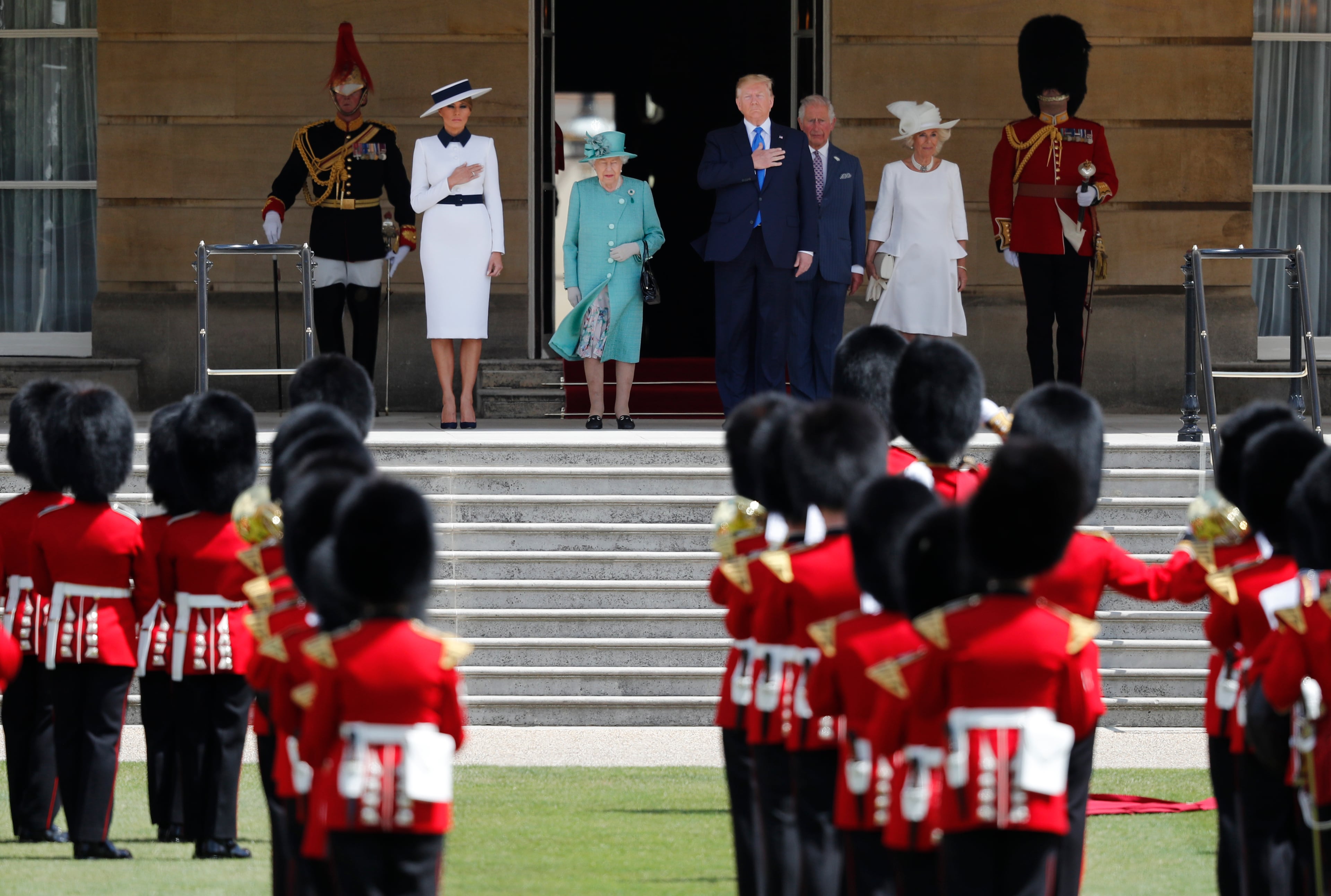 Britain's Queen Elizabeth II, President Donald Trump, first lady Melania Trump, Britain's Prince Charles and Camilla, Duchess of Cornwall, listen to the US national anthem during a ceremonial welcome in the garden of Buckingham Palace in London, Monday, June 3, 2019 on the opening day of a three day state visit to Britain. (AP Photo/Frank Augstein)
