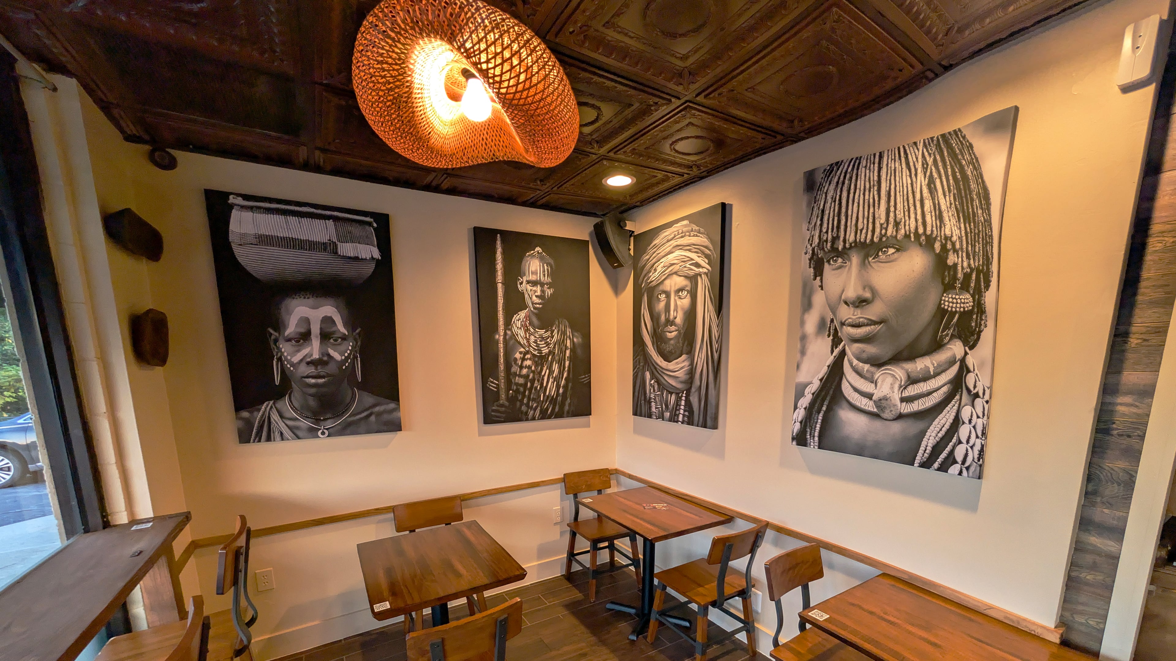 Coffee Therapy's interior includes a variety of cafe tables and booths and is decorated with large black and white portraits.