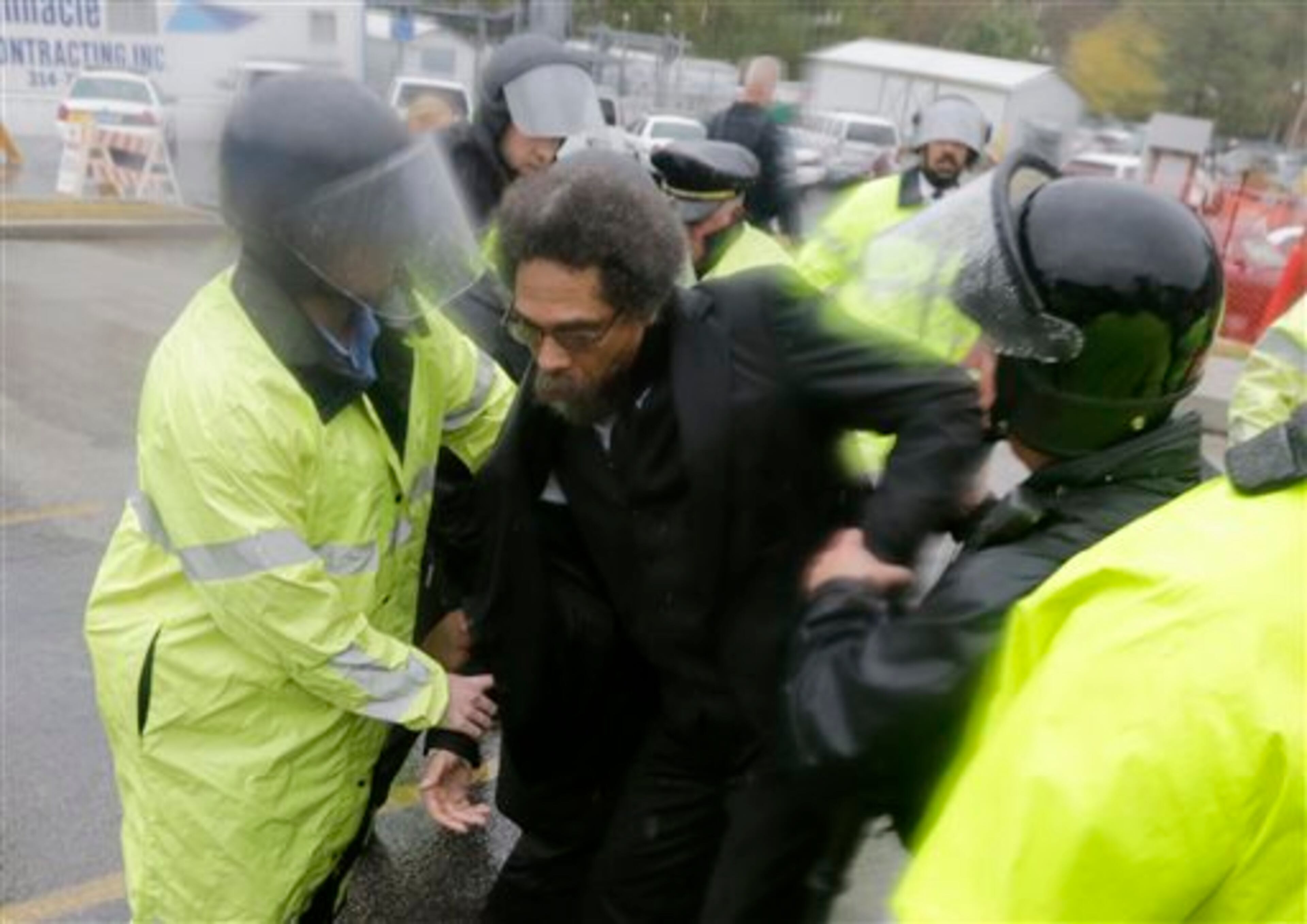 Philosopher Cornel West, center, is taken into custody after performing an act of civil disobedience at the Ferguson, Mo., police station Monday, Oct. 13, 2014, as hundreds continue to protest the fatal shooting of 18-year-old Michael Brown by police in August. In fact, tensions escalated last week when a white police officer shot and killed 18-year-old Vonderrit Myers Jr., who authorities say shot at police before he was killed. (AP Photo/Charles Rex Arbogast)
