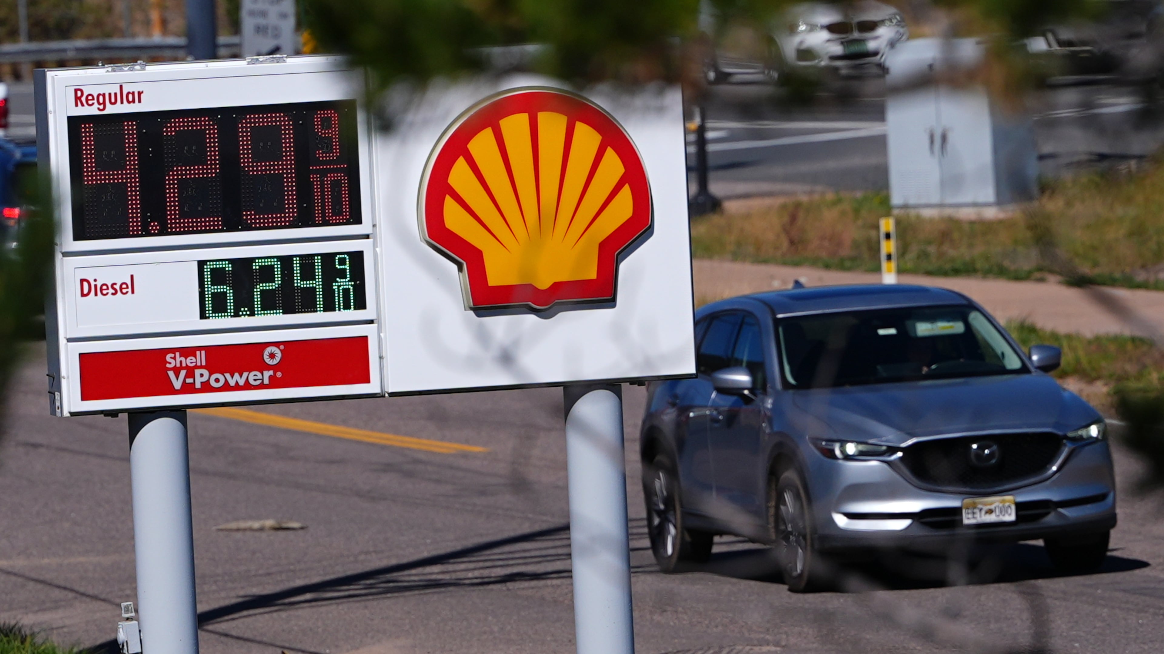 A motorist drives past a sign posting the per-gallon prices for regular unleaded and diesel fuel at a Shell gasoline station Monday, Oct. 5, 2026, in Evergreen, Colo. (AP Photo/David Zalubowski)
