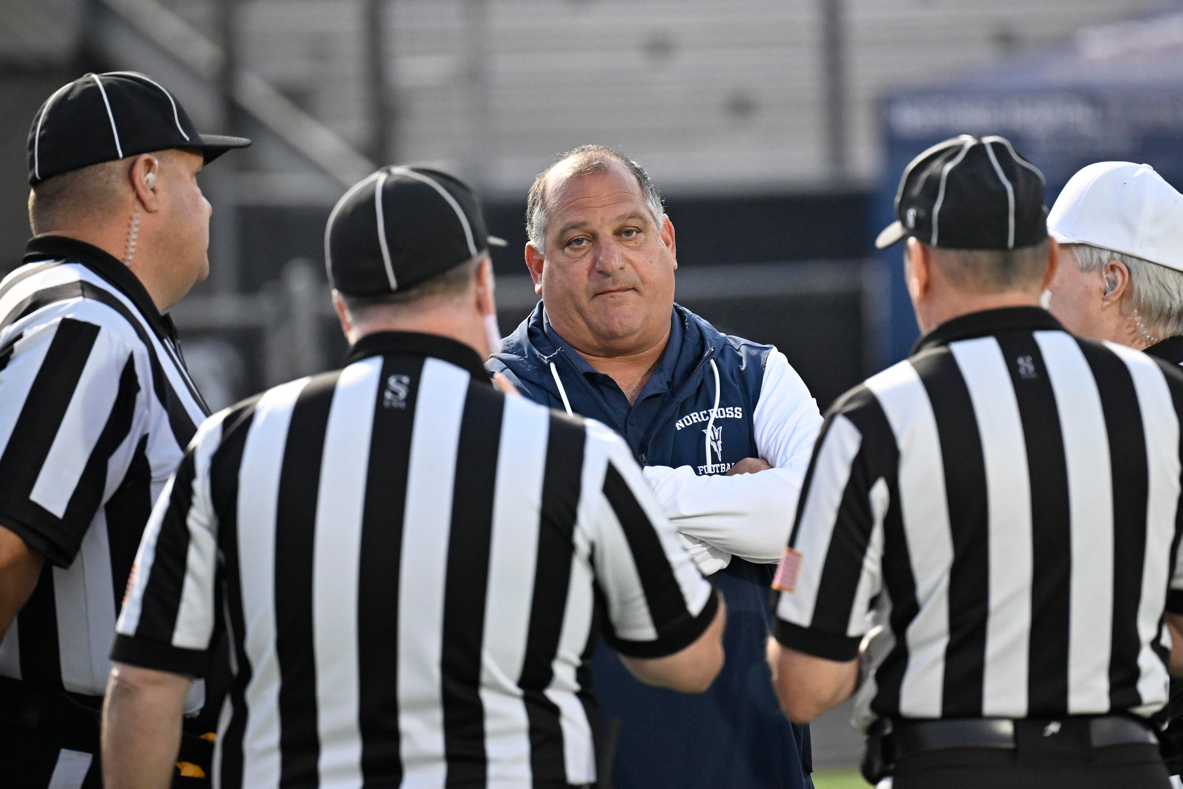 Norcross head coach Keith Maloof meets with officials before their GHSA region football game against N. Gwinnett in Suwanee, GA., on Friday, Oct. 25, 2024. (Jim Blackburn for the AJC)