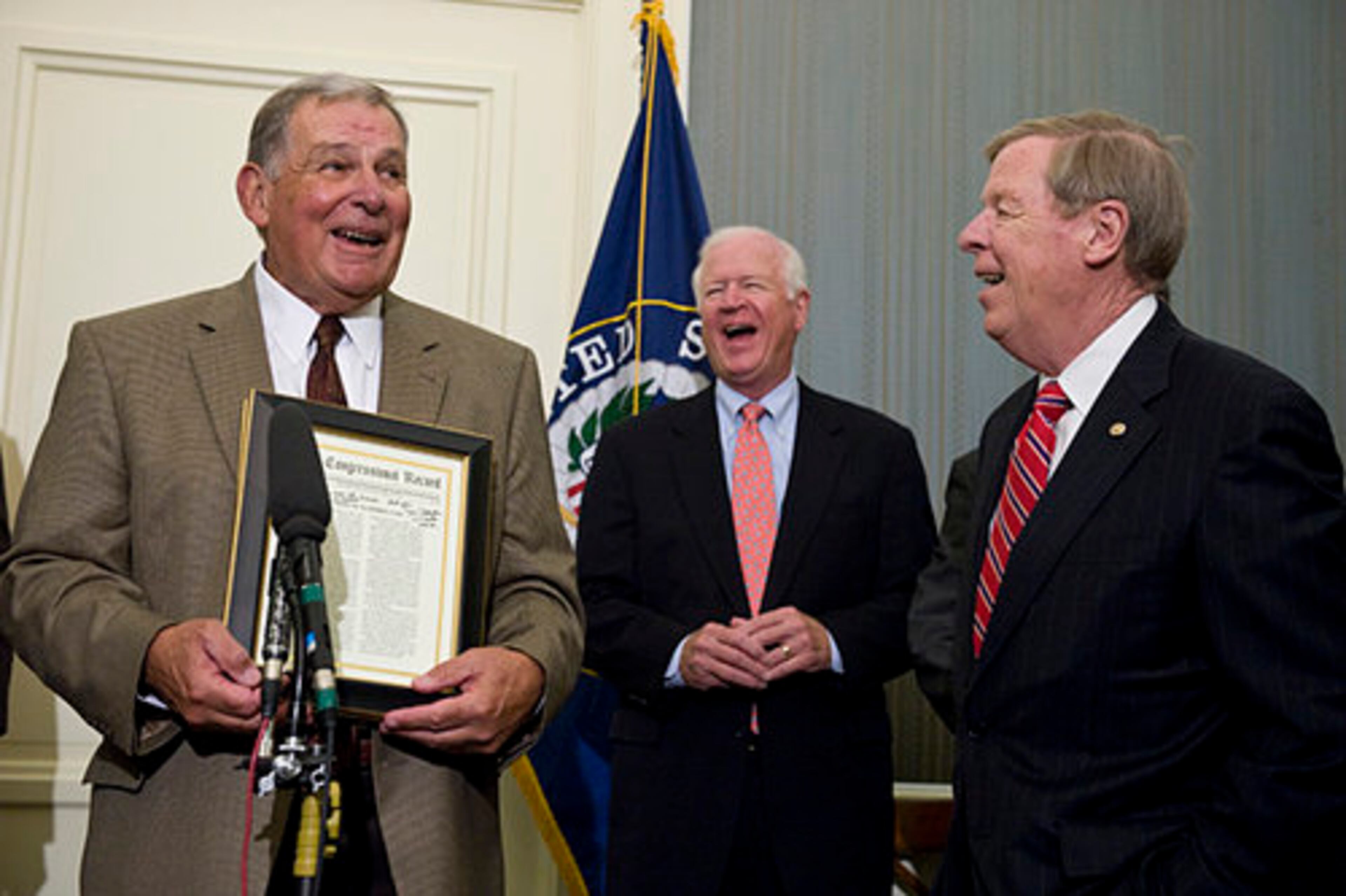 Braves manager Bobby Cox (left) speaks at the U.S. Capitol after being presented by Georgia senators Saxby Chambliss (center) and Johnny Isakson with copies of congressional statements honoring his career.