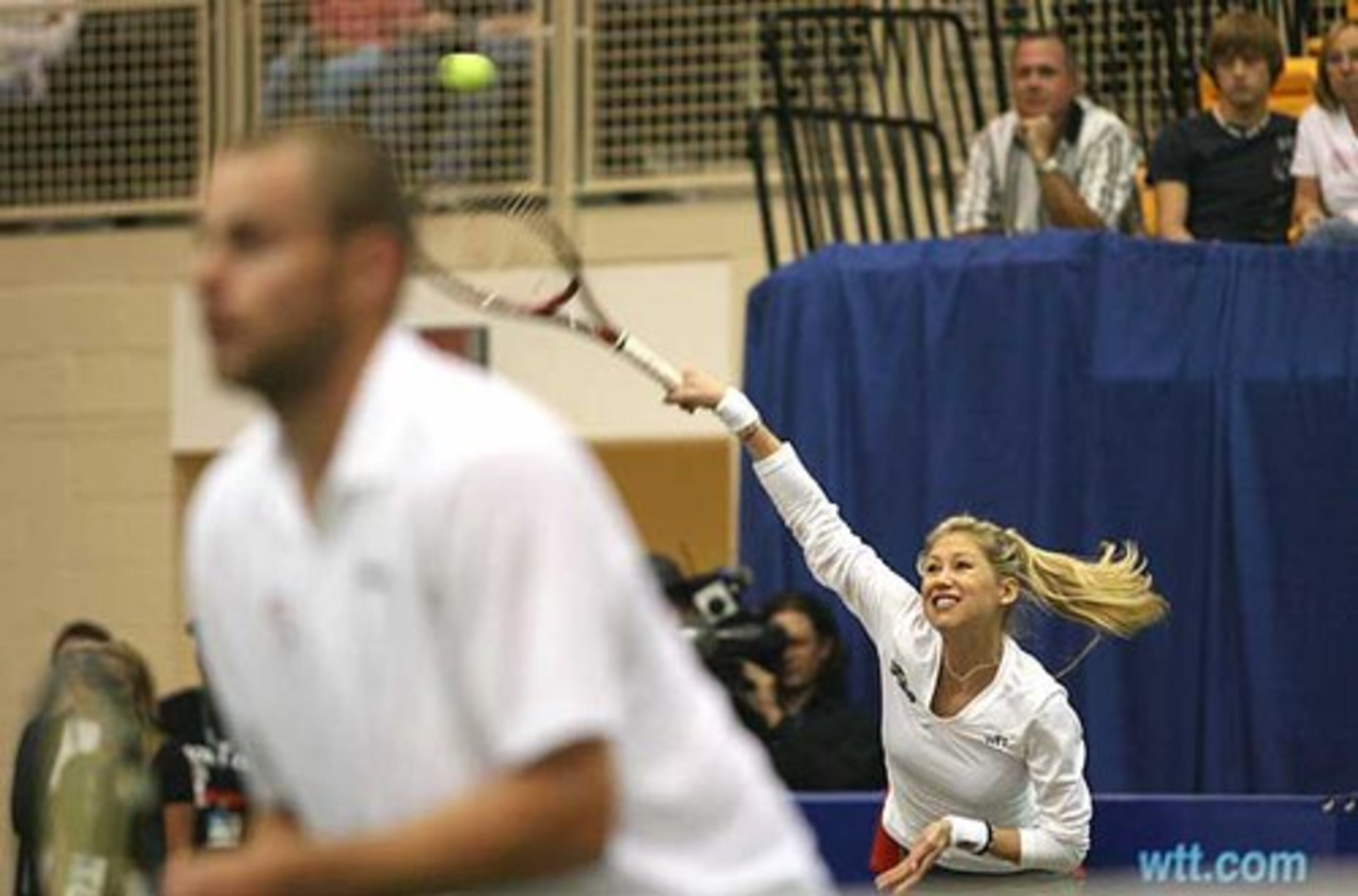 Anna Kournikova serves past doubles partner Andy Roddick during a mixed doubles match at the Advanta WTT Smash Hits tennis event.