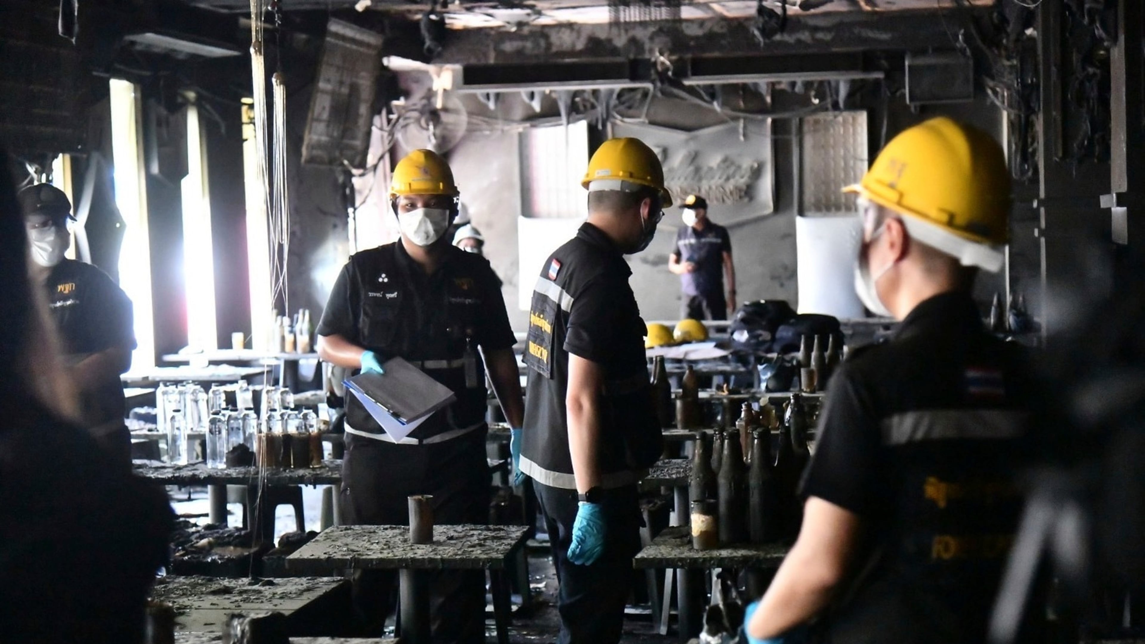 In this handout photo released by Bangkok Metropolitan Administration, forensic police officers inspect the site of a fire in Bangkok, Thailand, Monday, July 13, 2026. (Bangkok Metropolitan Administration via AP)