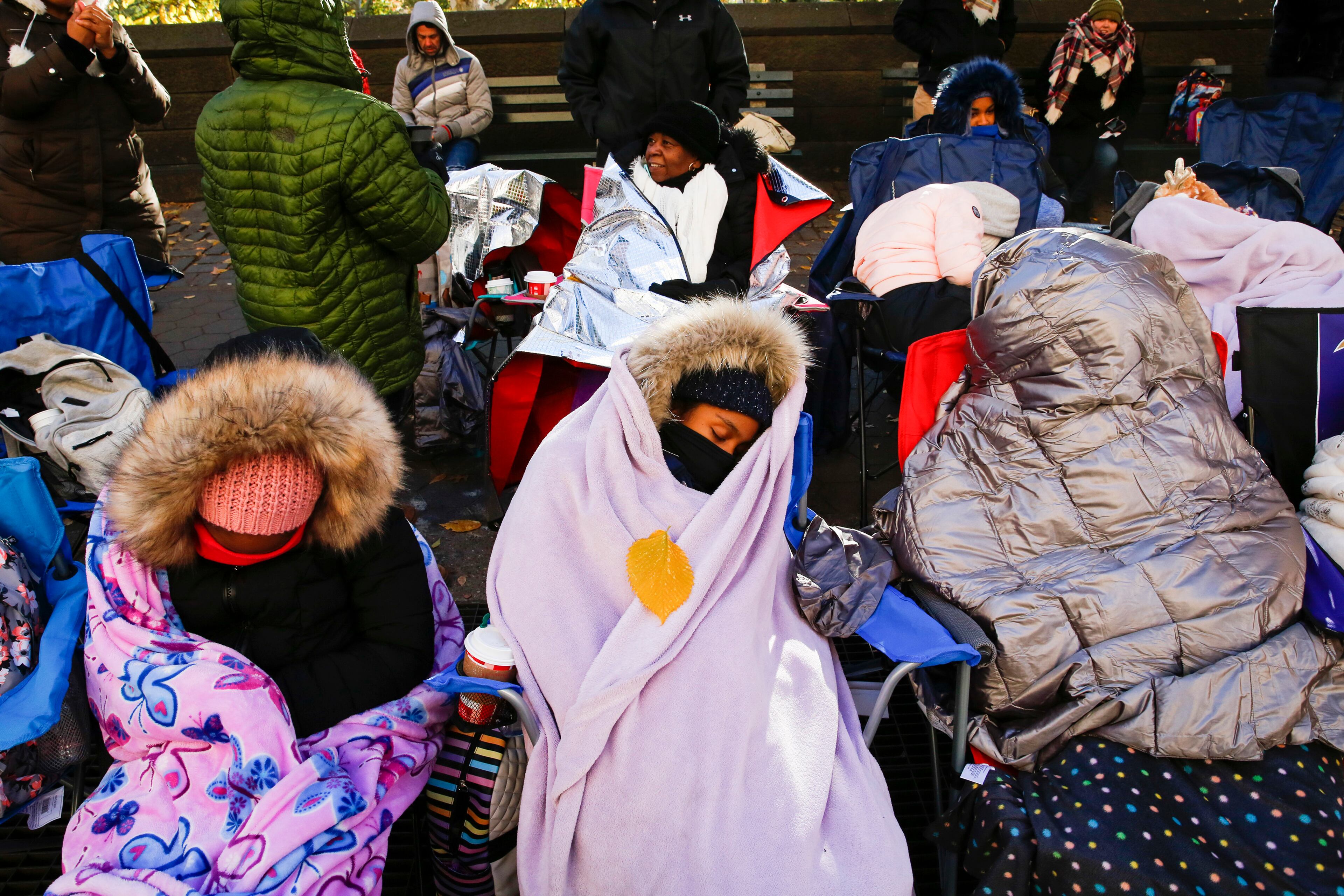 People try to stay warm as they wait for the start of the 92nd annual Macy's Thanksgiving Day Parade in New York, Thursday, Nov. 22, 2018. The 21 degrees (-6 Celsius) at the start of the parade made it one of the coldest Thanksgivings in the city in decades. (AP Photo/Eduardo Munoz Alvarez)