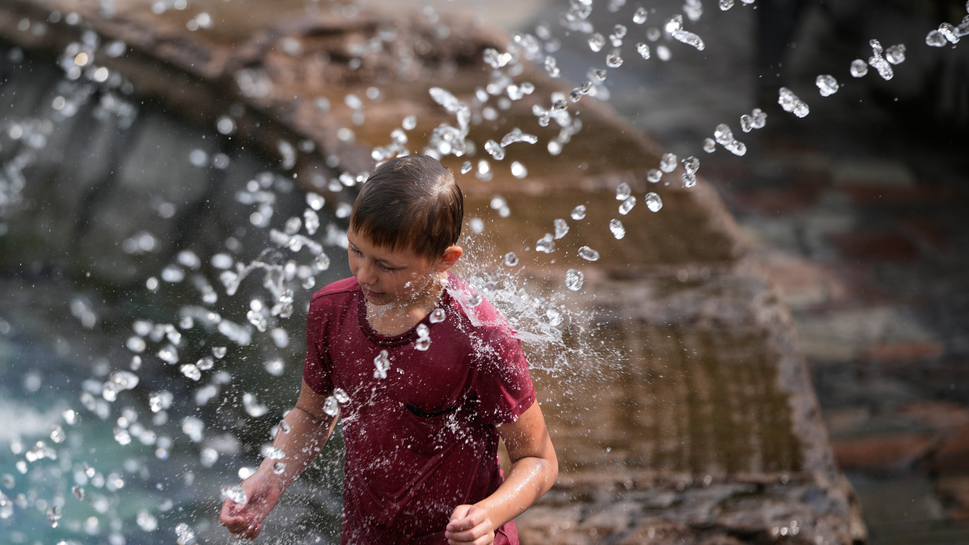 A boy cools himself off in a fountain on a hot summer day in Moscow, Thursday, Aug. 6, 2026. (AP Photo/Pavel Bednyakov)
