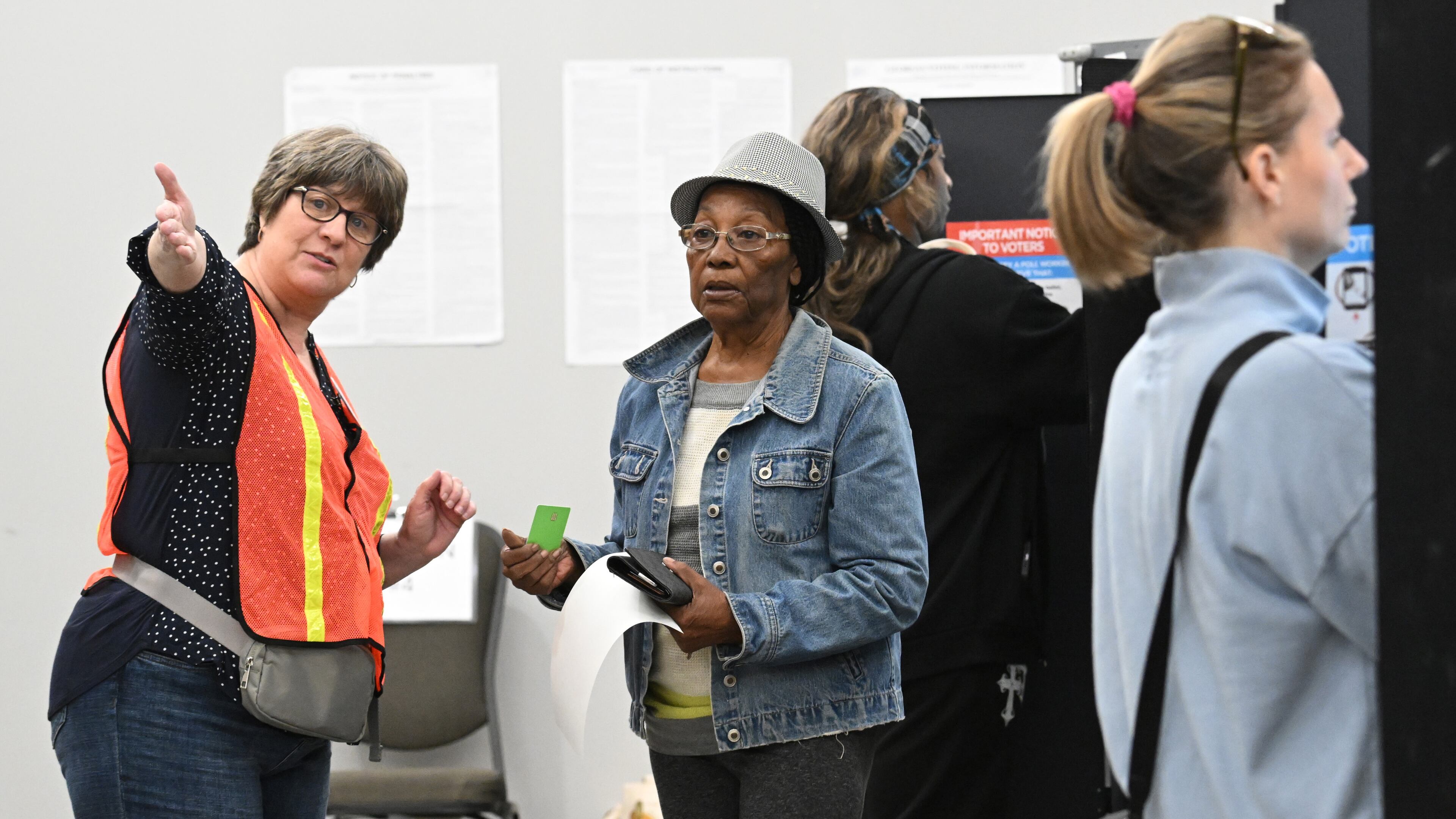 A poll worker helps voter Joyce Fraser (center) on Oct. 15 at the Cobb County Elections and Registration Office in Marietta. (Hyosub Shin/AJC)