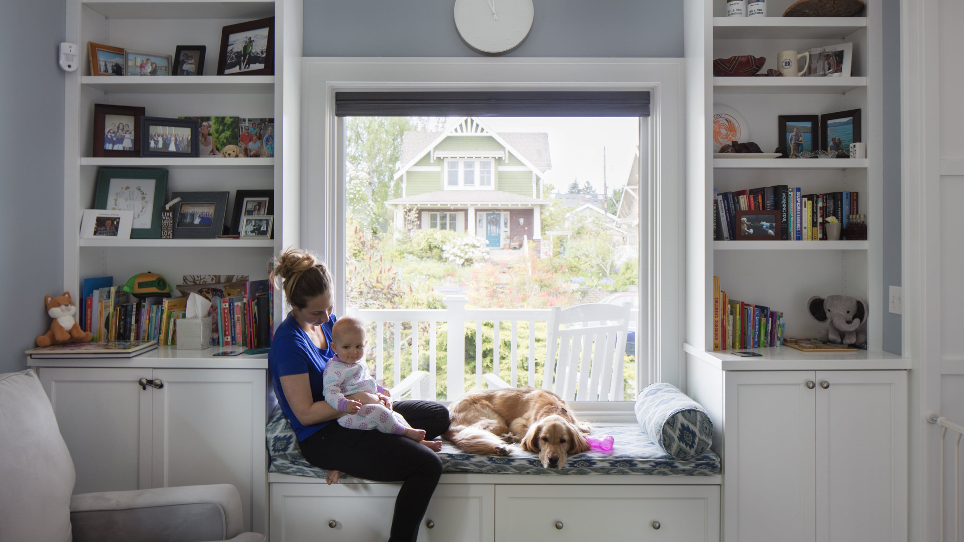 Kaitlyn Tamulonis holds daughter Julia as Kascade curls up on the window seat in the newly cozy and bright front room. The original fireplace (out of view) was maintained, but with a reskinned chimney. “We liked the aesthetic even if we didn’t use it,” says Jason Tamulonis. “But it had a hideous facade.” (Steve Ringman/Seattle Times/TNS)