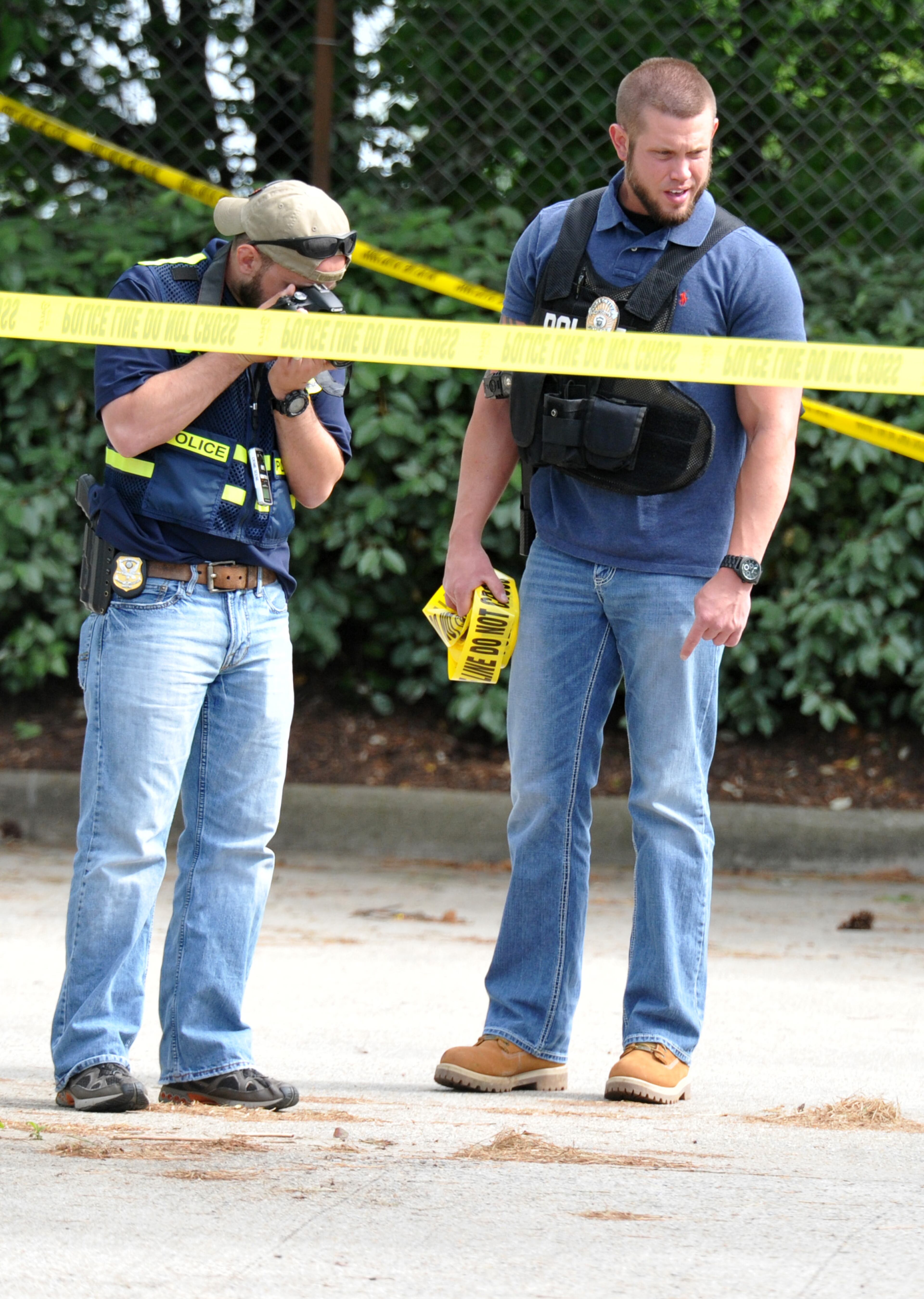 Authorities investigate in the parking lot of Pappadeaux Seafood Kitchen, where at least one victim was shot multiple times, near the intersection of I-85 and Jimmy Carter Boulevard in Norcross on Friday afternoon, May 2, 2014. HYOSUB SHIN / HSHIN@AJC.COM