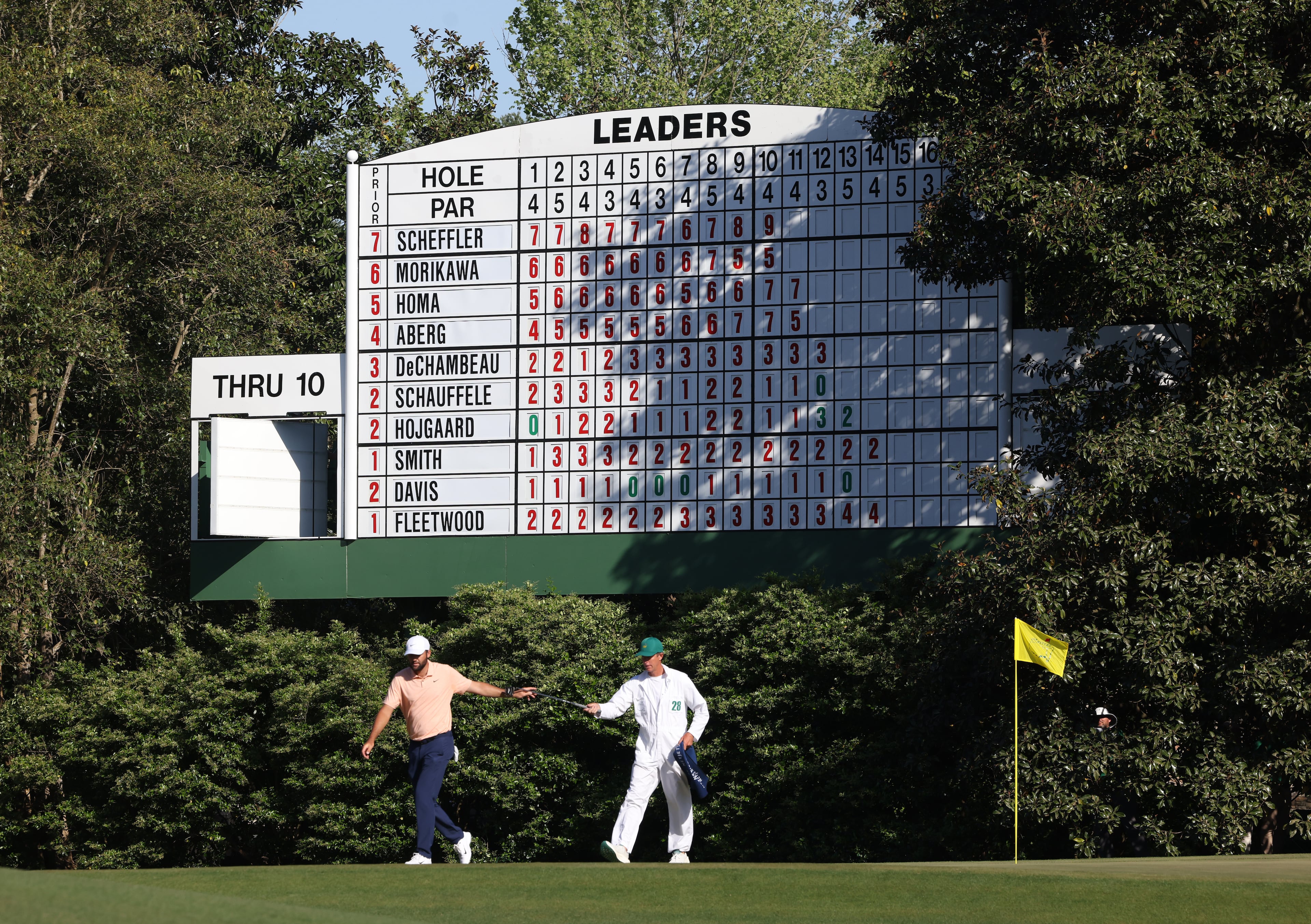 Scottie Scheffler gives his putter to his caddie Ted Scott after birdie putt on 11th hole during the final round of the 2024 Masters Tournament at Augusta National Golf Club, Sunday, April 14, 2024, in Augusta, Ga. Jason Getz / Jason.Getz@ajc.com)