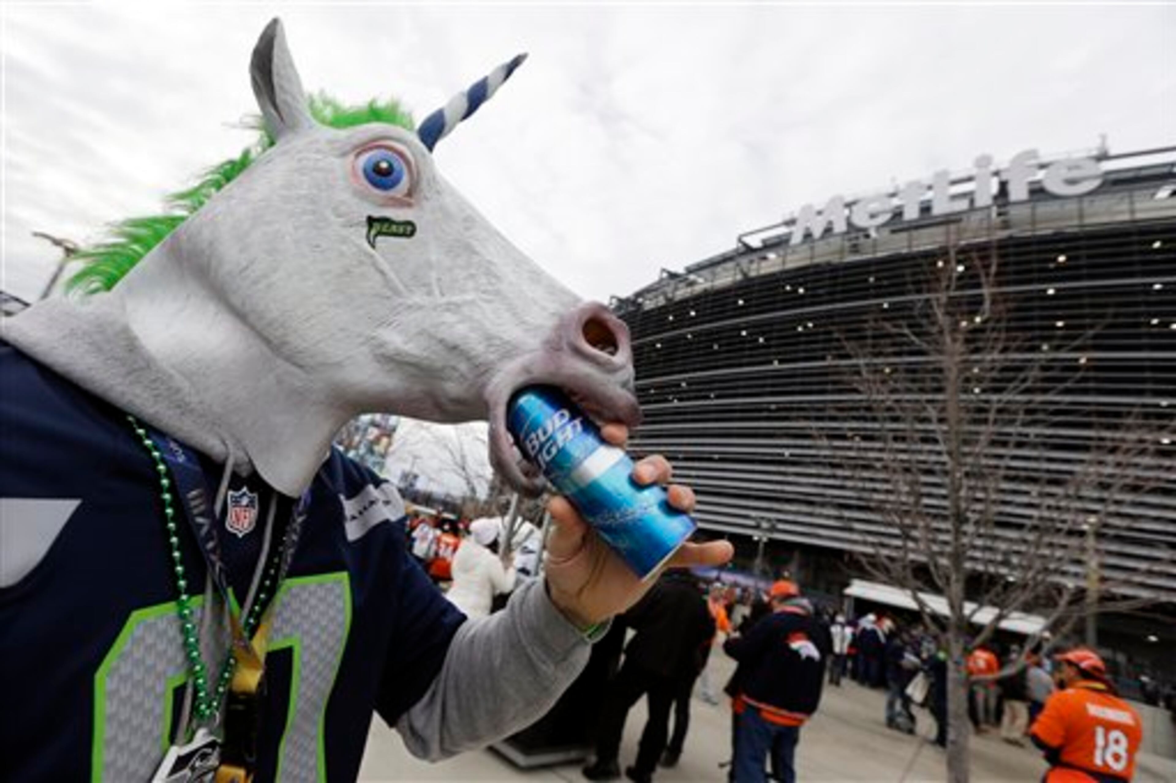 Kellan Smalley, in a unicorn head, from Bremerton Wash., drinks a beer outside MetLife Stadium before the NFL Super Bowl XLVIII football game between the Seattle Seahawks and the Denver Broncos, Sunday, Feb. 2, 2014, in East Rutherford, N.J. (AP Photo/Seth Wenig)