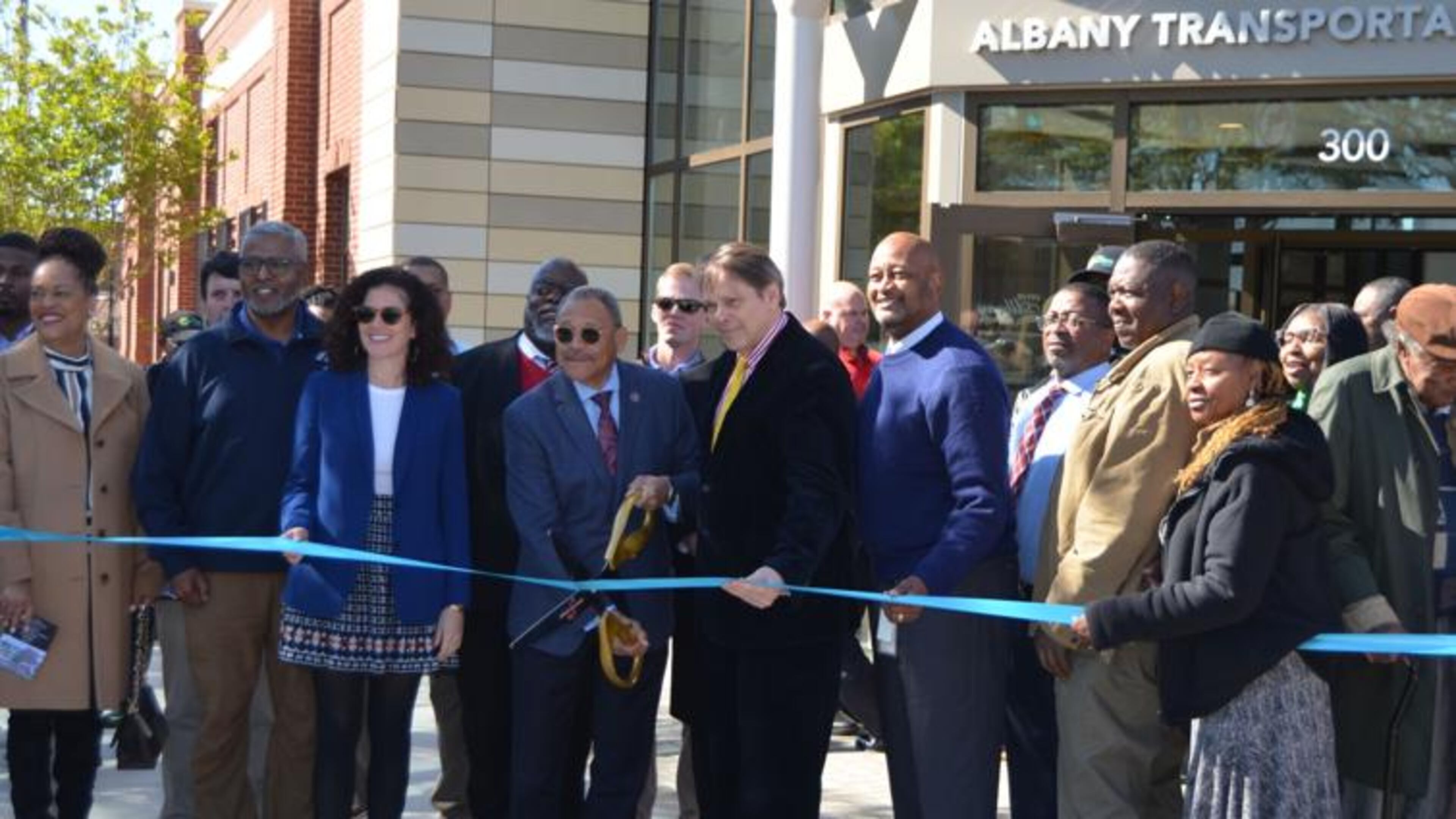 U.S. Rep. Sanford Bishop, holding scissors, and other dignitaries cut the ribbon for the new Albany Transportation Center on Monday. The new facility opens in a week. (Photo Courtesy of Alan Mauldin)