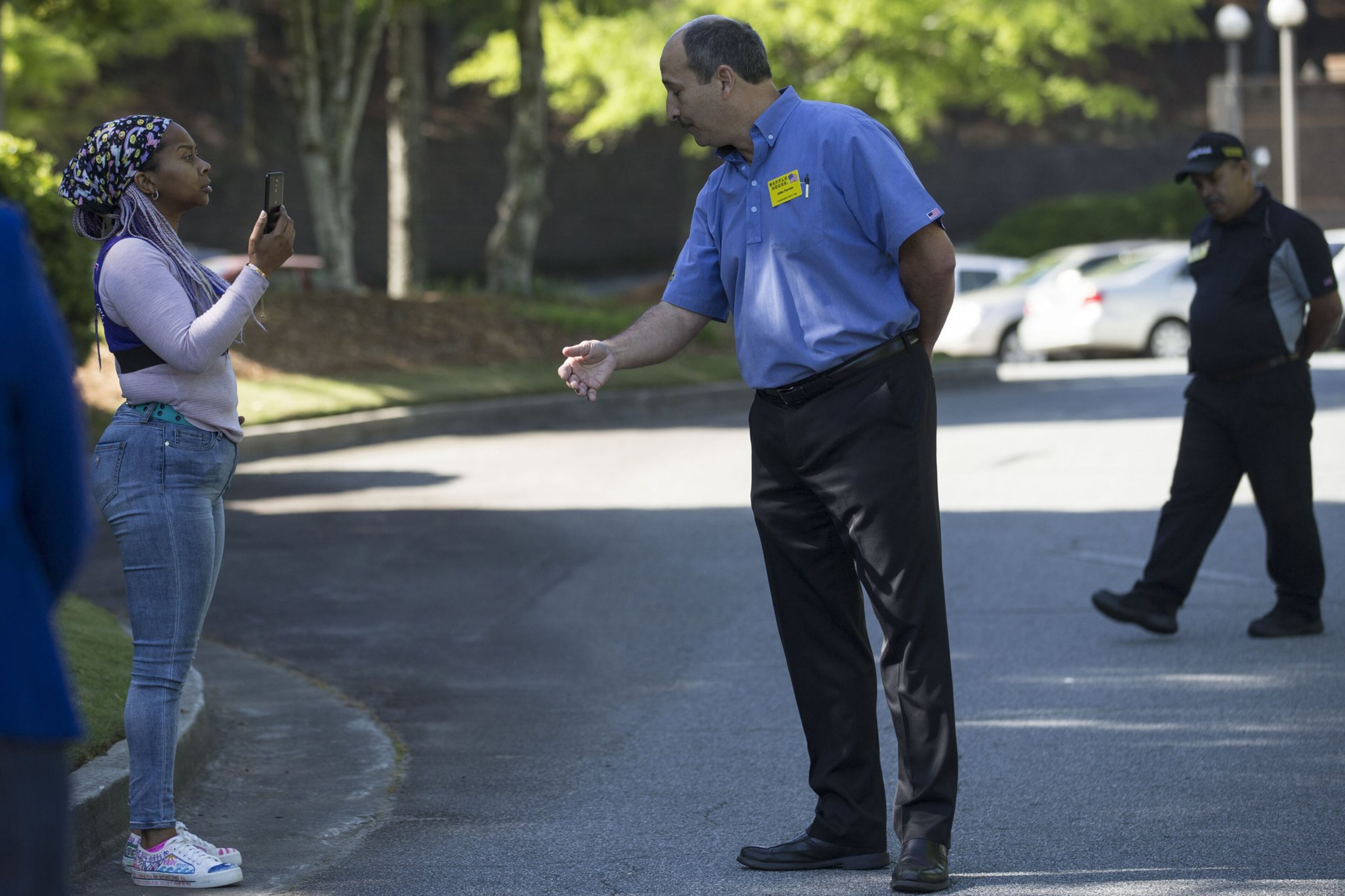 04/30/2018 — Norcross, GA - Waffle House Vice President of risk management John Fervier, center, asks Nicole Borden, left, to walk off the Waffle House corporate campus headquarters in Norcross, Monday, April 30, 2018. Nicole and others gathered outside of the metro Atlanta Waffle House corporate campus in order to protest and demand action following a recent incident at a Alabama Waffle House that left a 25-year-old black woman, Chikesia Clemons, violently arrested. ALYSSA POINTER/ALYSSA.POINTER@AJC.COM