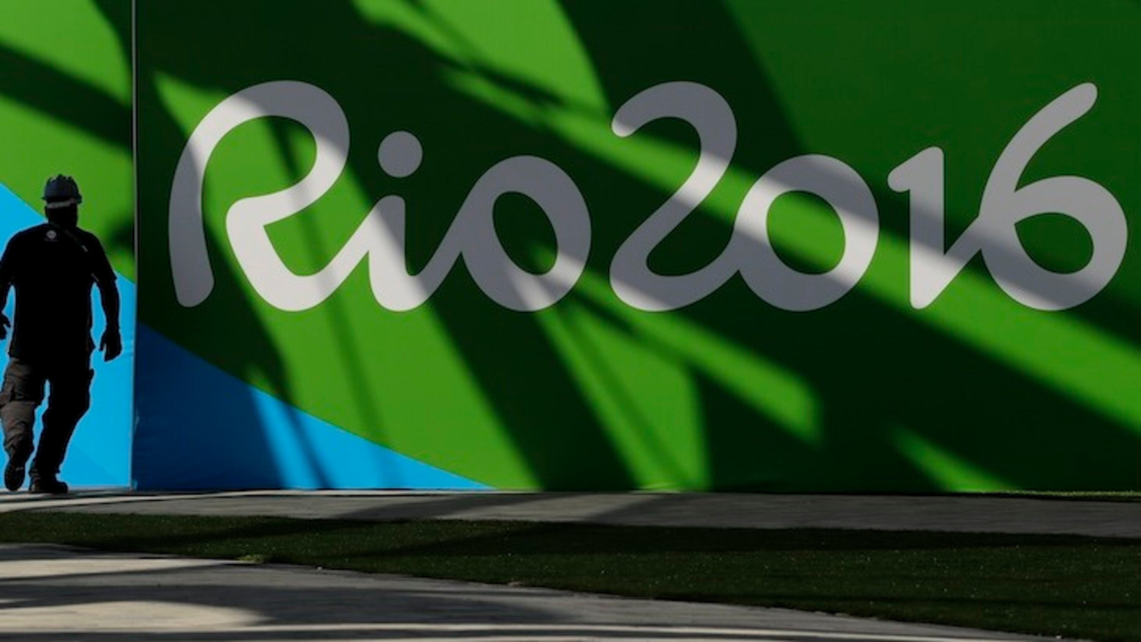 A worker walks past a sign for the Rio Olympics while making preparations at Olympic Park in Rio de Janeiro, Brazil, Wednesday, July 27, 2016. (AP Photo/Charlie Riedel)