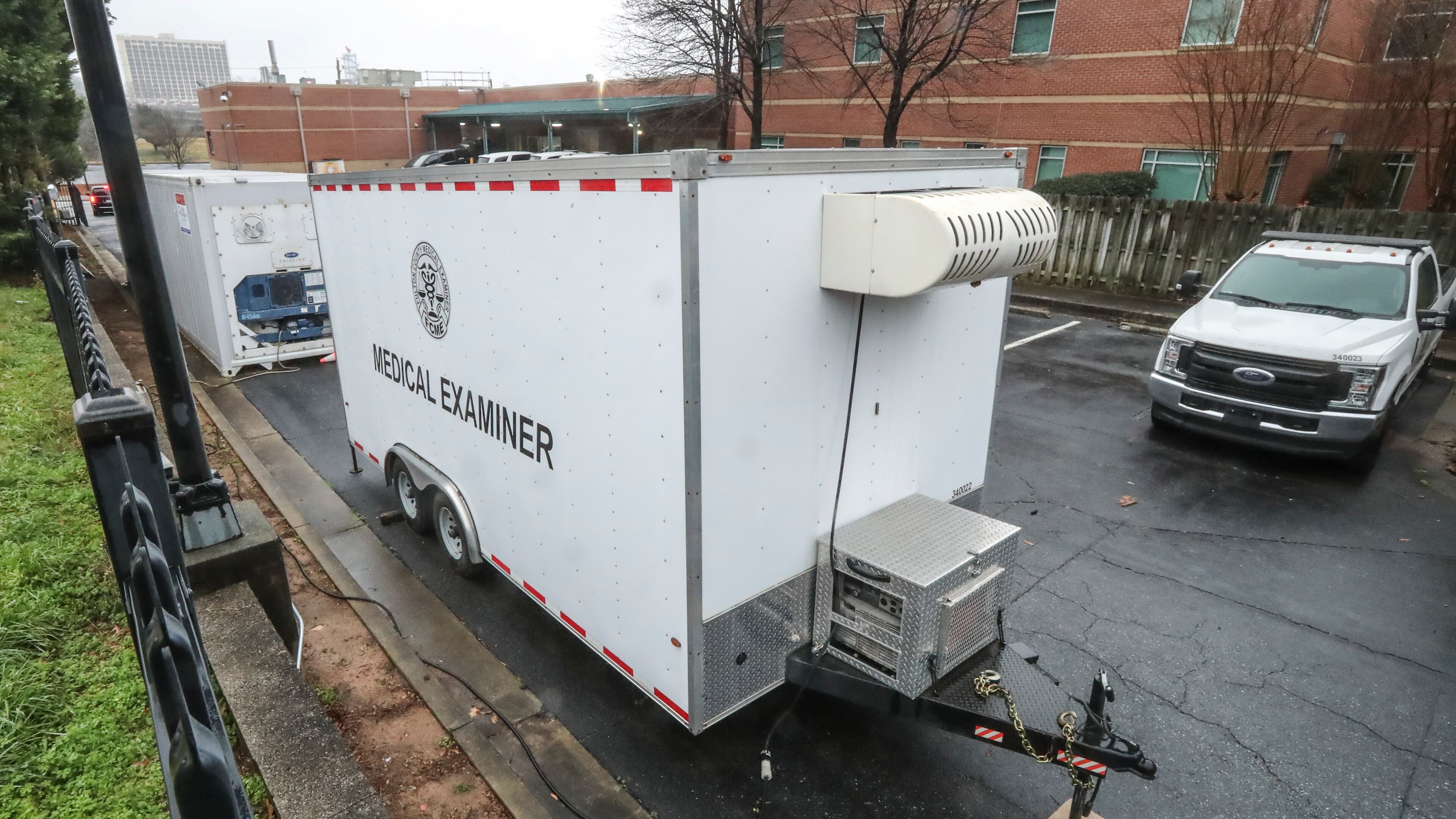 January 8, 2021 Atlanta: Trailers parked outside of the Fulton County Medical Examiner’s office located at 430 Pryor St SW in Atlanta (NOT CONFIRMED if these are used for overflow morgue). Health officials saw the COVID-19 surge coming and sounded alarms, but the holiday get-togethers went on. Now, the scenes officials have dreaded the most since the start of the pandemic are playing out all over Georgia. Hospitals overflow with COVID-19 patients. Some nursing homes are erupting with new cases. Vaccinations are behind, and, for lack of staff, some health districts are limiting COVID testing to get the shots to health care workers and the elderly. Meanwhile, with deaths mounting, the Fulton County Medical Examiner’s office has deployed a refrigerated morgue truck to store bodies. A second truck is ready to go. (John Spink / John.Spink@ajc.com)