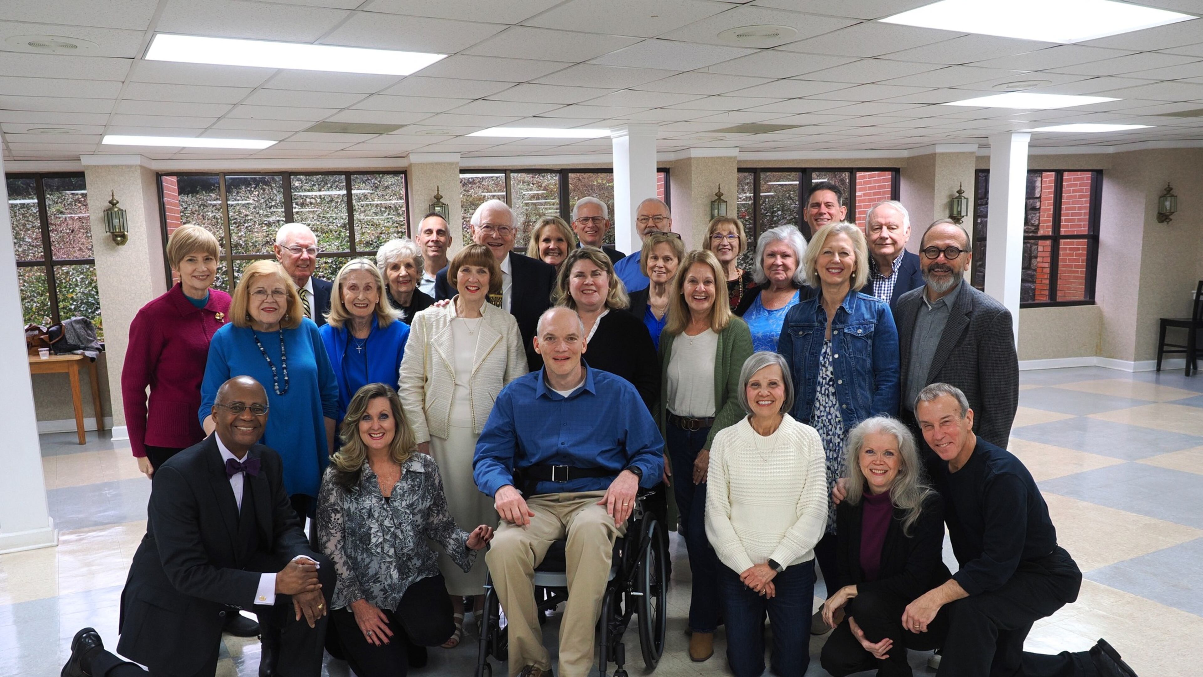 Wayne Mote (in wheelchair) and his wife Lori Mote, standing behind him, are surrounded by many friends at a recent event. Last month, the Peachtree City Fire & Rescue Department's special events crew won a state award for saving Mote's life last year. (Courtesy of Ken Ezell)