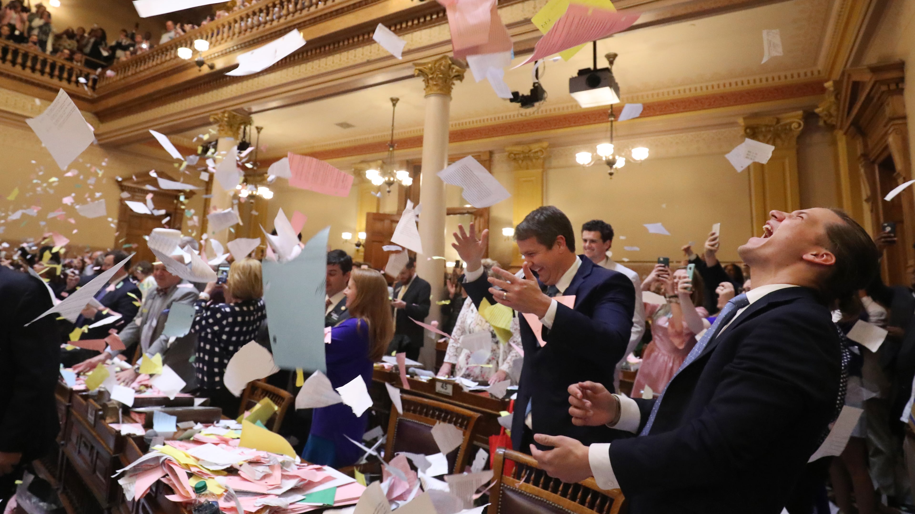 March 29, 2018 - Atlanta, Ga: Jared Williams, right, throws a large pile of paper in the air next to his father, Sen. Michael Williams, R-Cumming, left, as Sine Die was proclaimed shortly after midnight during Legislative Day 40 in the Senate Chamber at the Georgia State Capitol Thursday, March 29, 2018, in Atlanta. PHOTO / JASON GETZ