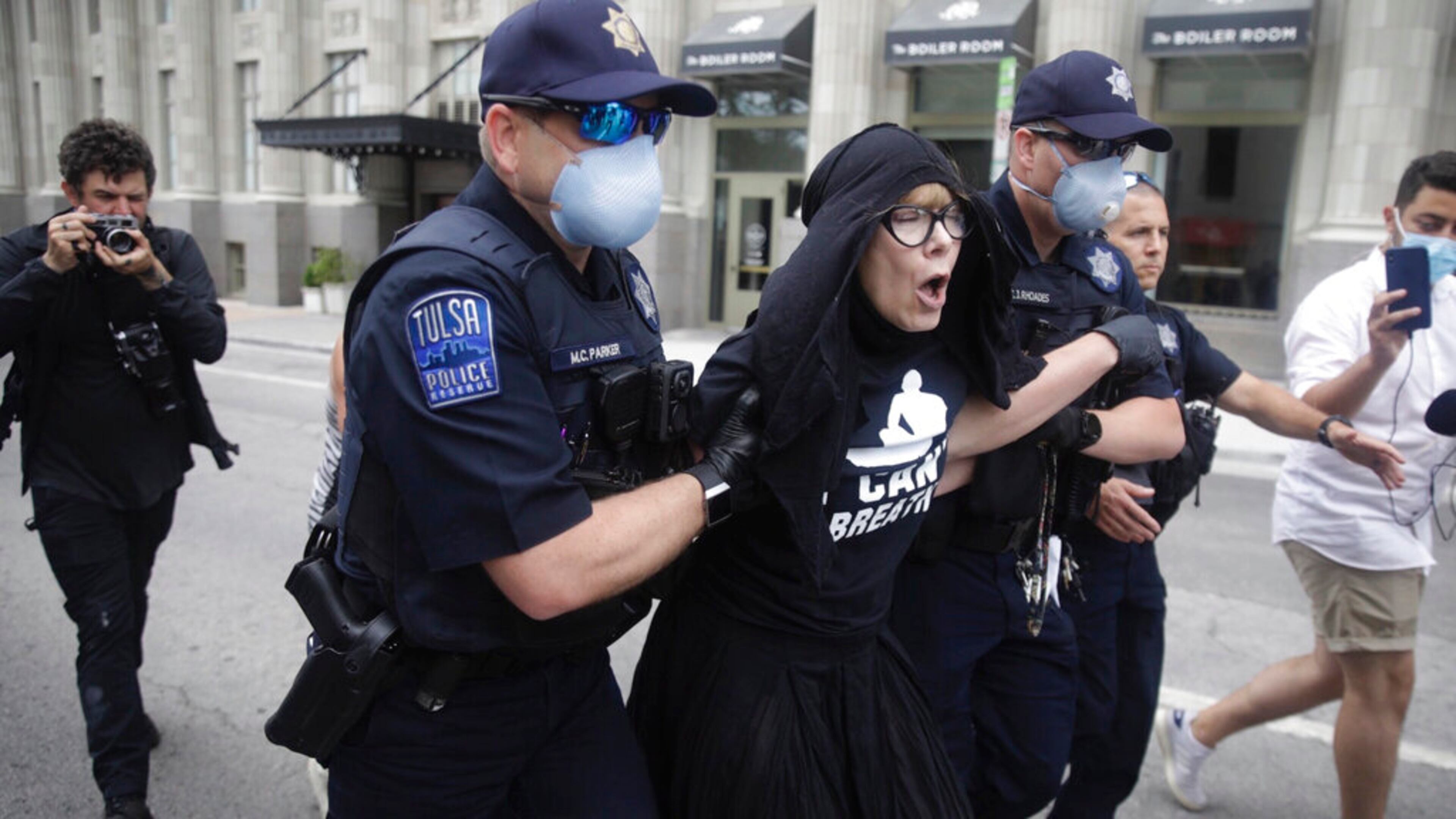 Tulsa Police officers arrest protester for trespassing after she entered the safety barricade of President Donald Trump's campaign rally Saturday June 20, 2020. (Mike Simons/Tulsa World via AP)