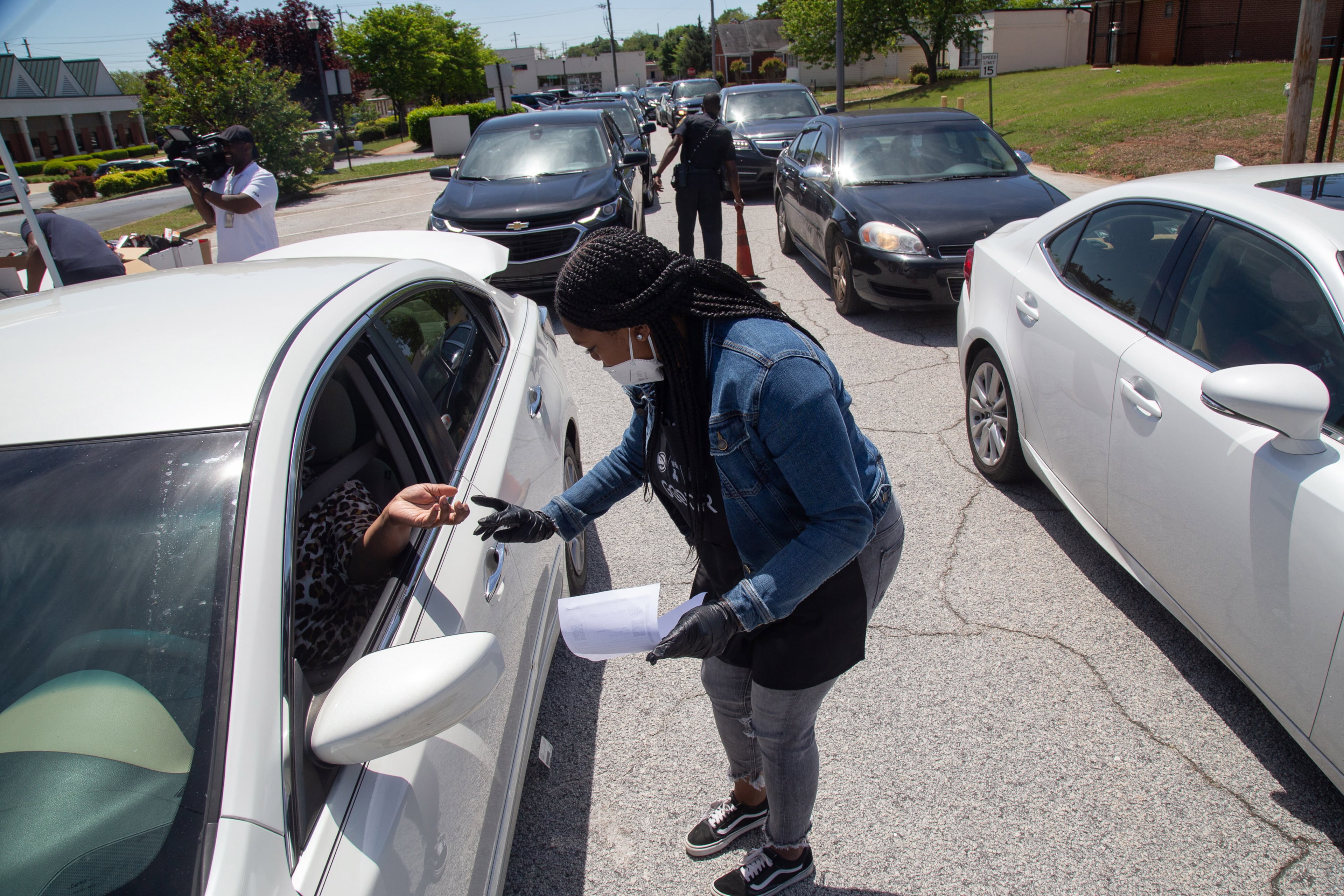 Jasmine Crowe checks the driver's pre-registration during the City of College Park Recreation and Cultural Arts Department's first pop-up grocery store Saturday, April 18, 2020. STEVE SCHAEFER / SPECIAL TO THE AJC