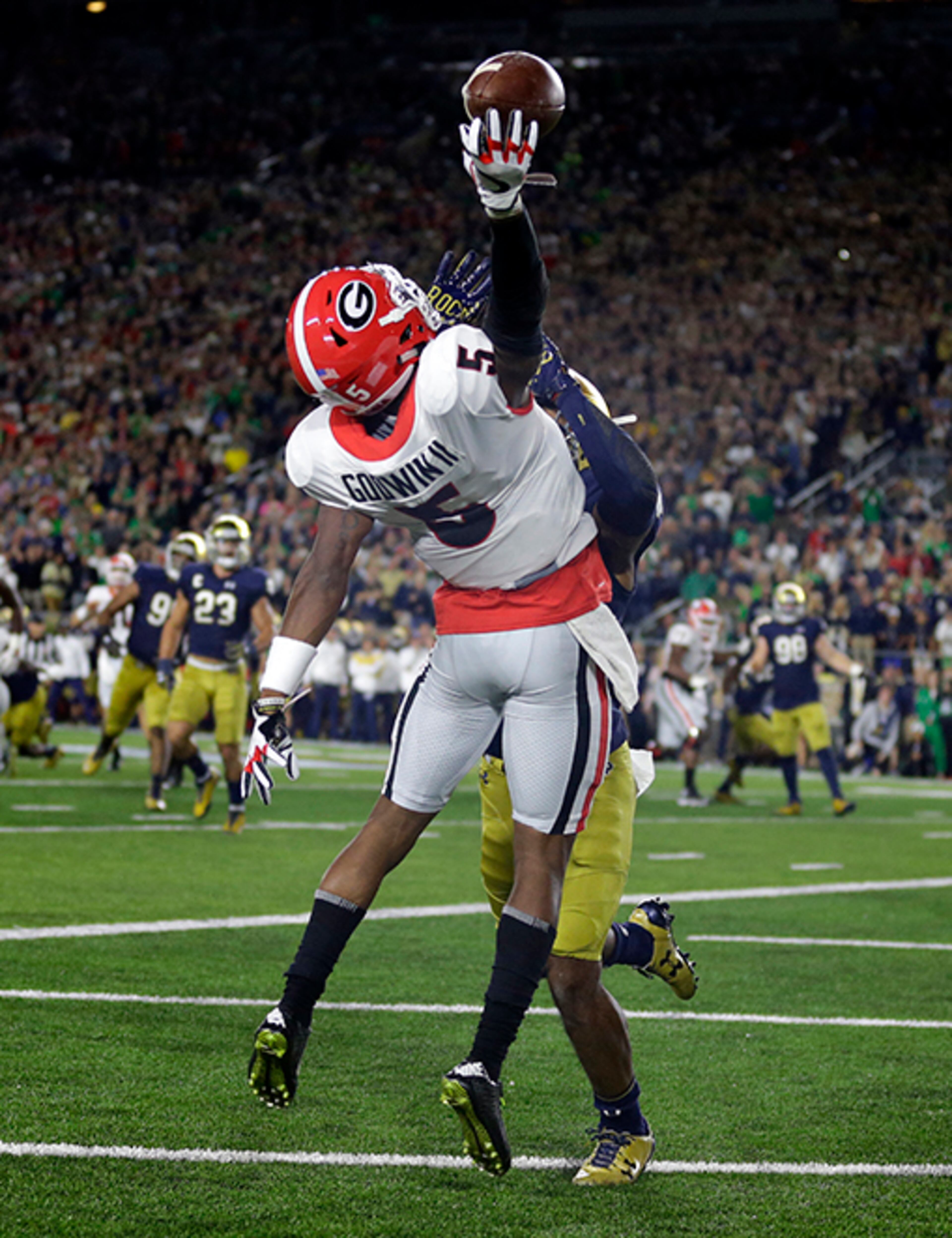 Georgia wide receiver Terry Godwin (5) makes a catch over Notre Dame cornerback Julian Love for a touchdown during the first half of an NCAA college football game in South Bend, Ind., Saturday, Sept. 9, 2017. (AP Photo/Michael Conroy)