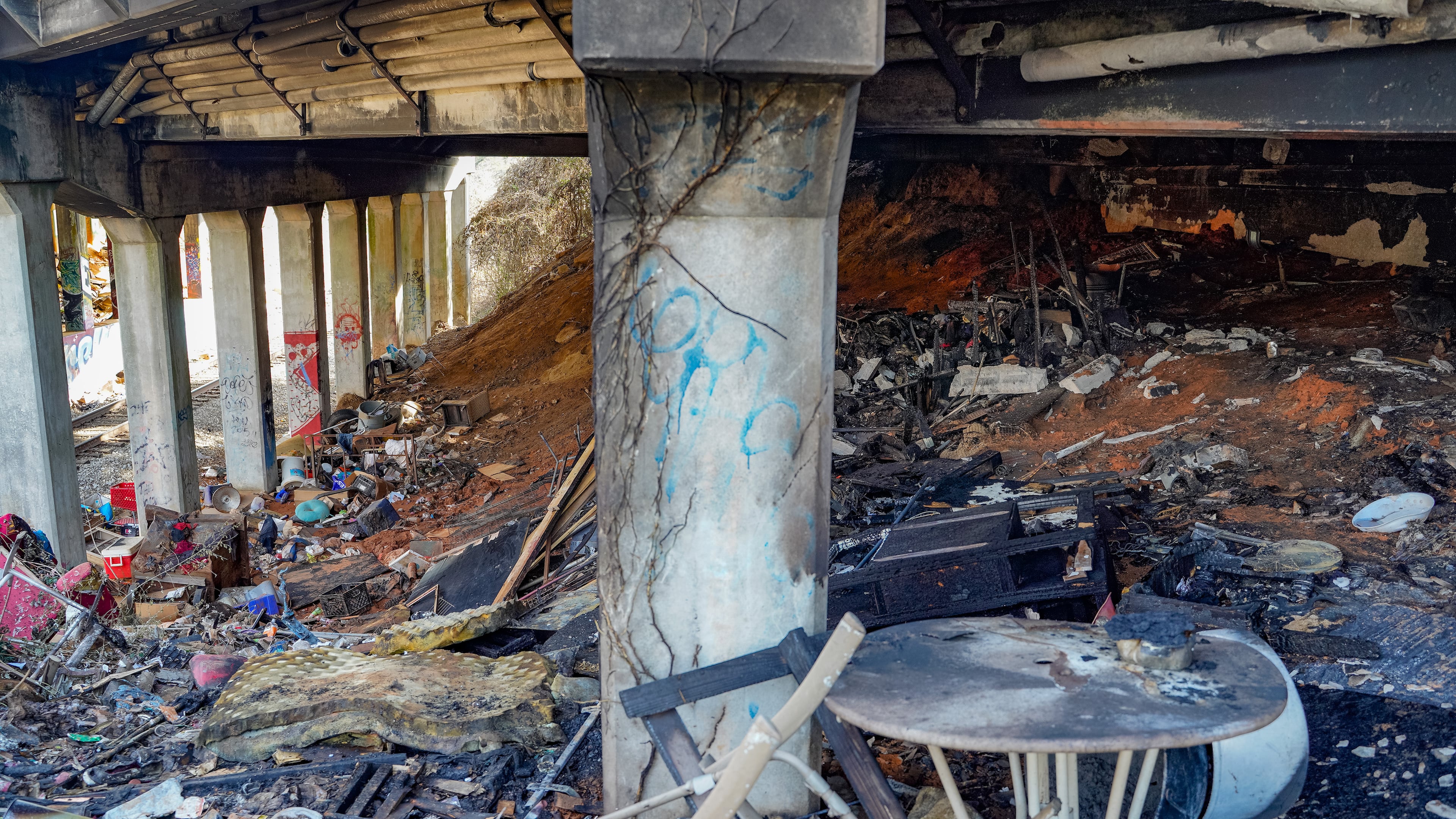 Charred items that may have been part of a homeless encampment were left after a fire off Cheshire Bridge Road early Wednesday.