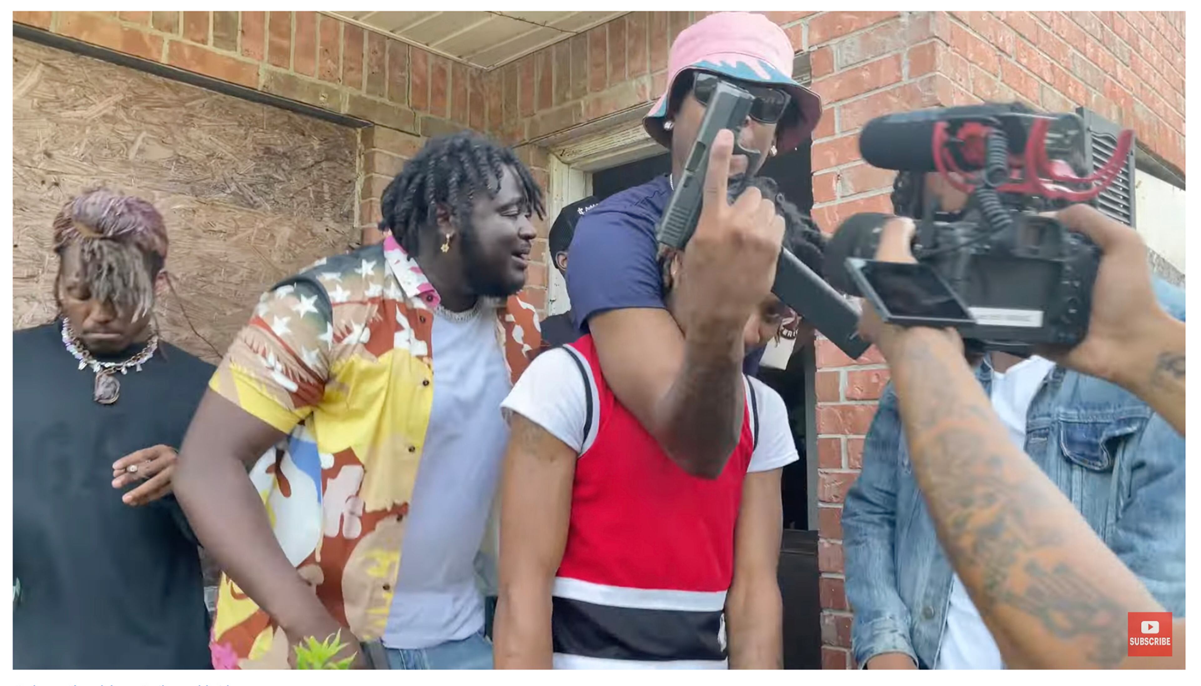 An online video posted earlier this year shows men posing with guns as they film a music video outside a boarded-up building at Pinebrooke Apartments near Riverdale. (Miko Worldwide / YouTube)