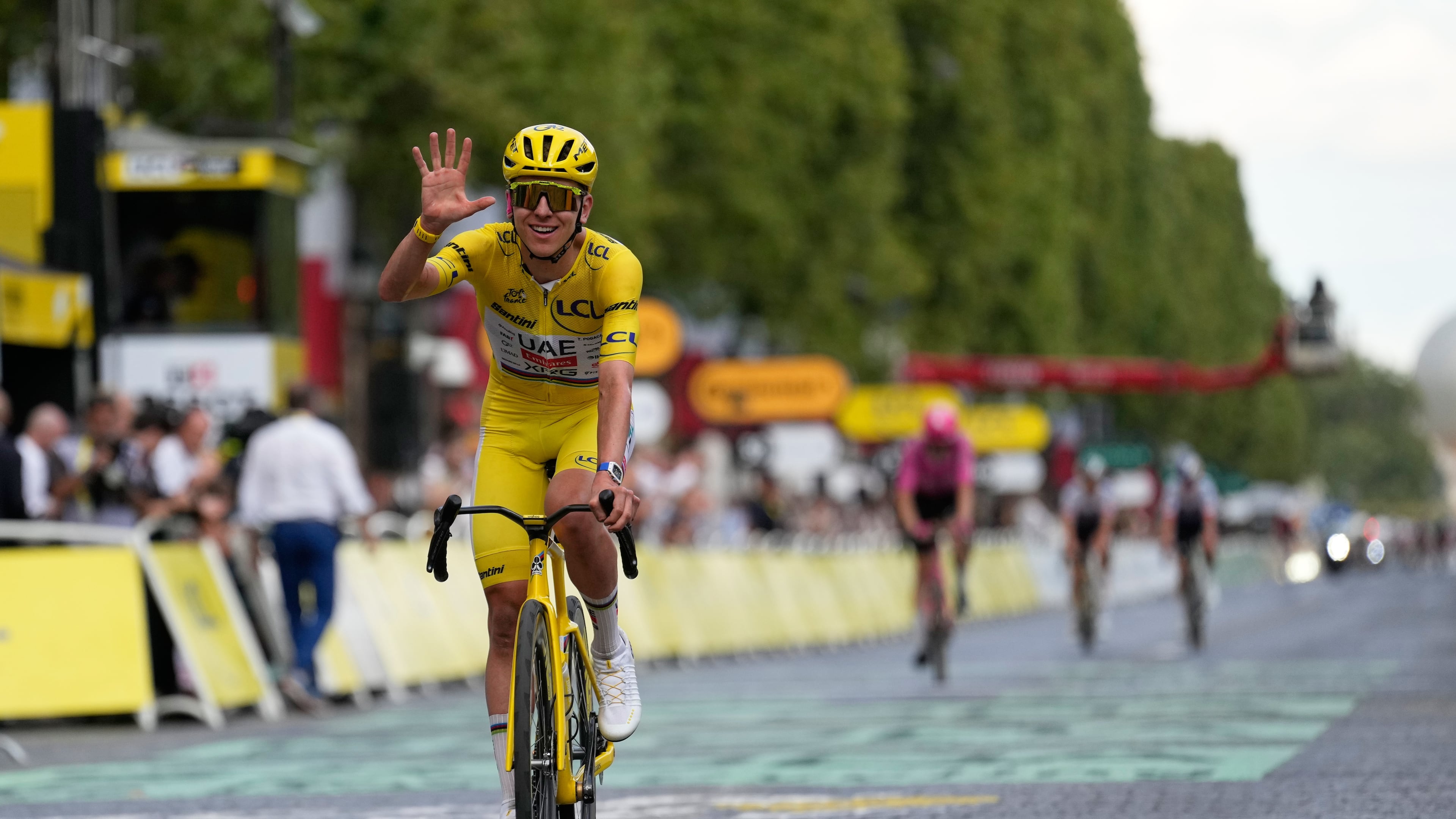 Slovenia's Tadej Pogacar, wearing the overall leader's yellow jersey, celebrates as he crosses the finish line of the last stage of the Tour de France cycling race with start and finish in Paris, Sunday, July 26, 2026. (AP Photo/Mosa'ab Elshamy)