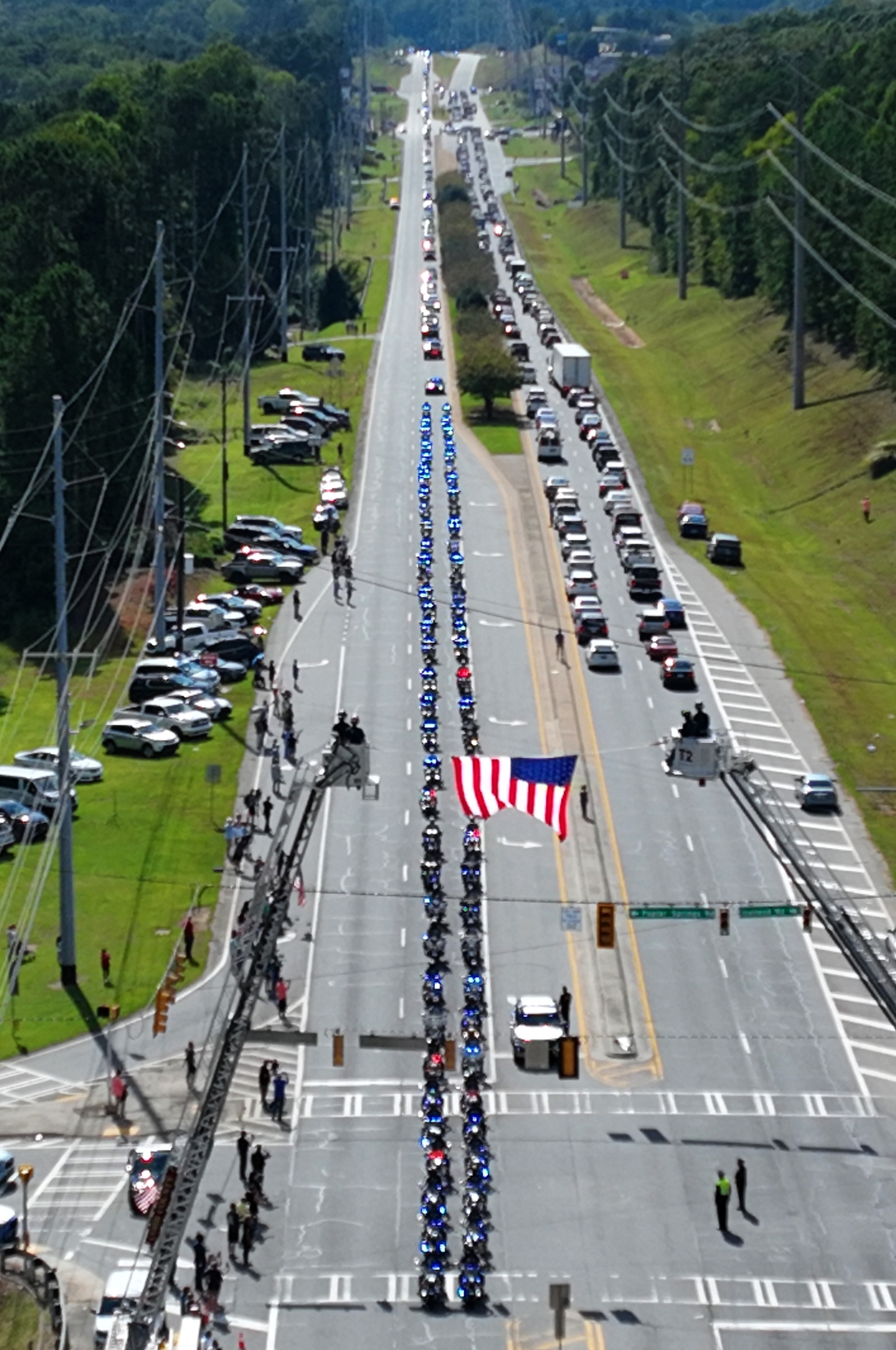 September 15, 2022 Dallas - Aerial photograph shows the funeral procession of Deputy Marshall Samuel Ervin Jr. on Dallas Highway in Dallas on Thursday, September 15, 2022. Law enforcement and community members honor Deputy Marshall Samuel Ervin Jr., who was killed in the line of duty. (Hyosub Shin / Hyosub.Shin@ajc.com)