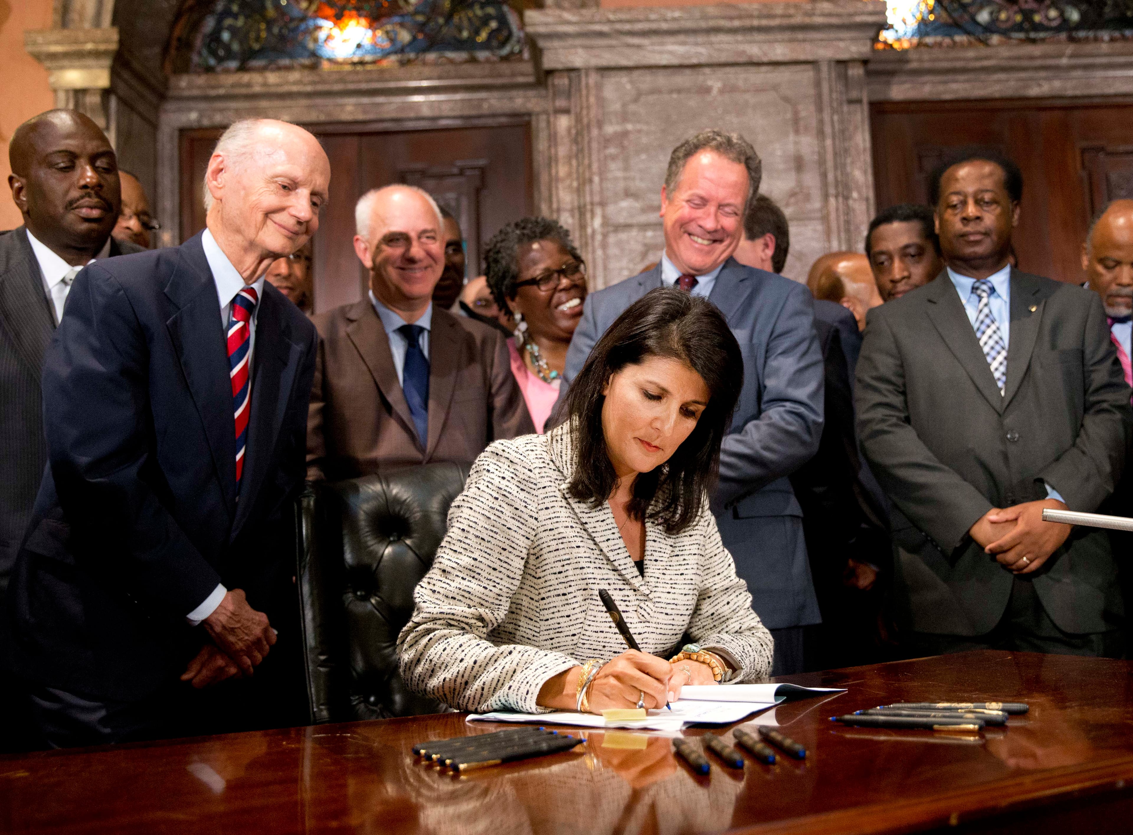 Former South Carolina Gov. David Beasley, standing second from right, watches as Gov. Nikki Haley signs a law in 2015 enabling the removal of the Confederate flag from the South Carolina Capitol (John Bazemore/AP)