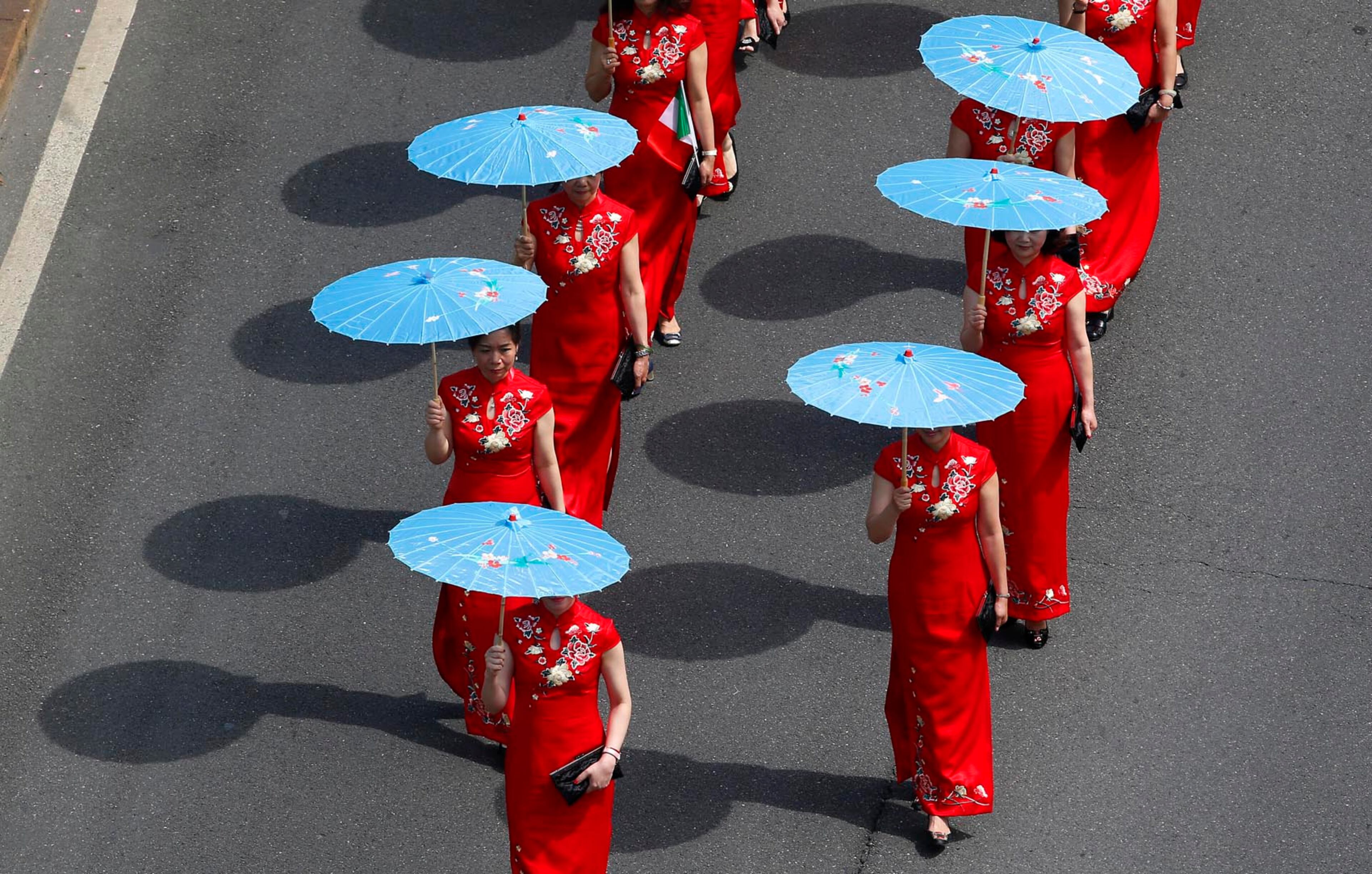 A group of Chinese girls march in downtown Milan, Italy, Saturday, May 20, 2017 as they take part to a demonstration in support of migrants' rights. (AP Photo/Antonio Calanni)