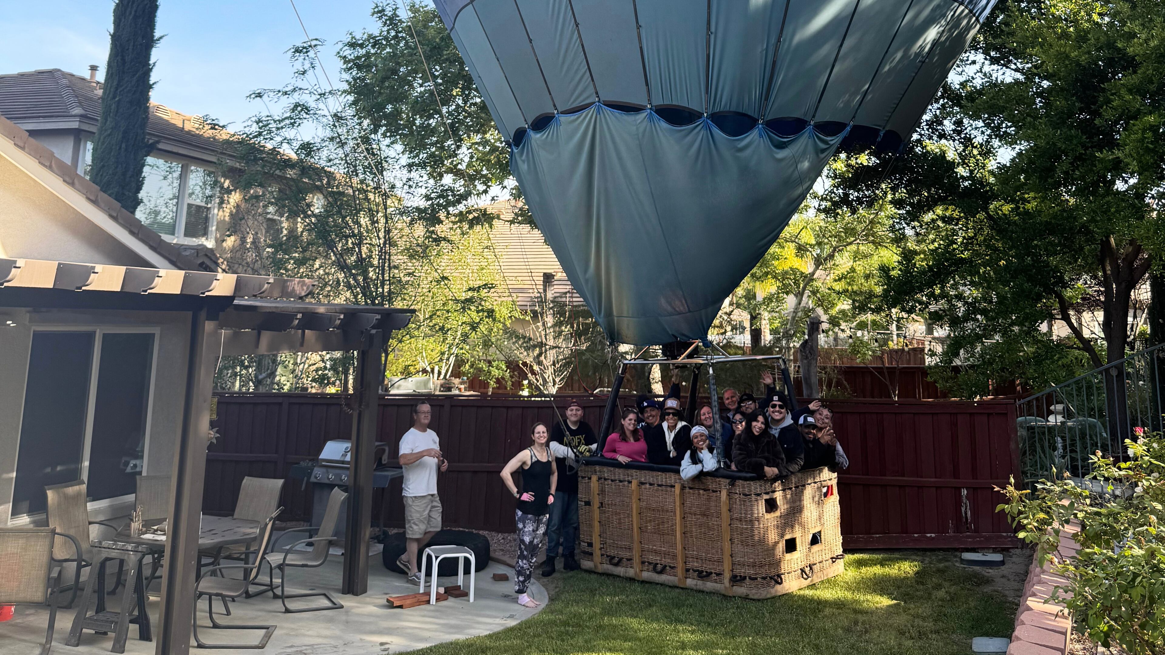 This photo provided by Hunter Perrin shows people riding a hot air balloon posing for a photo after making an emergency landing in Perrin's backyard on Saturday, April 18, 2026, in Temecula, Calif. (Hunter Perrin via AP)