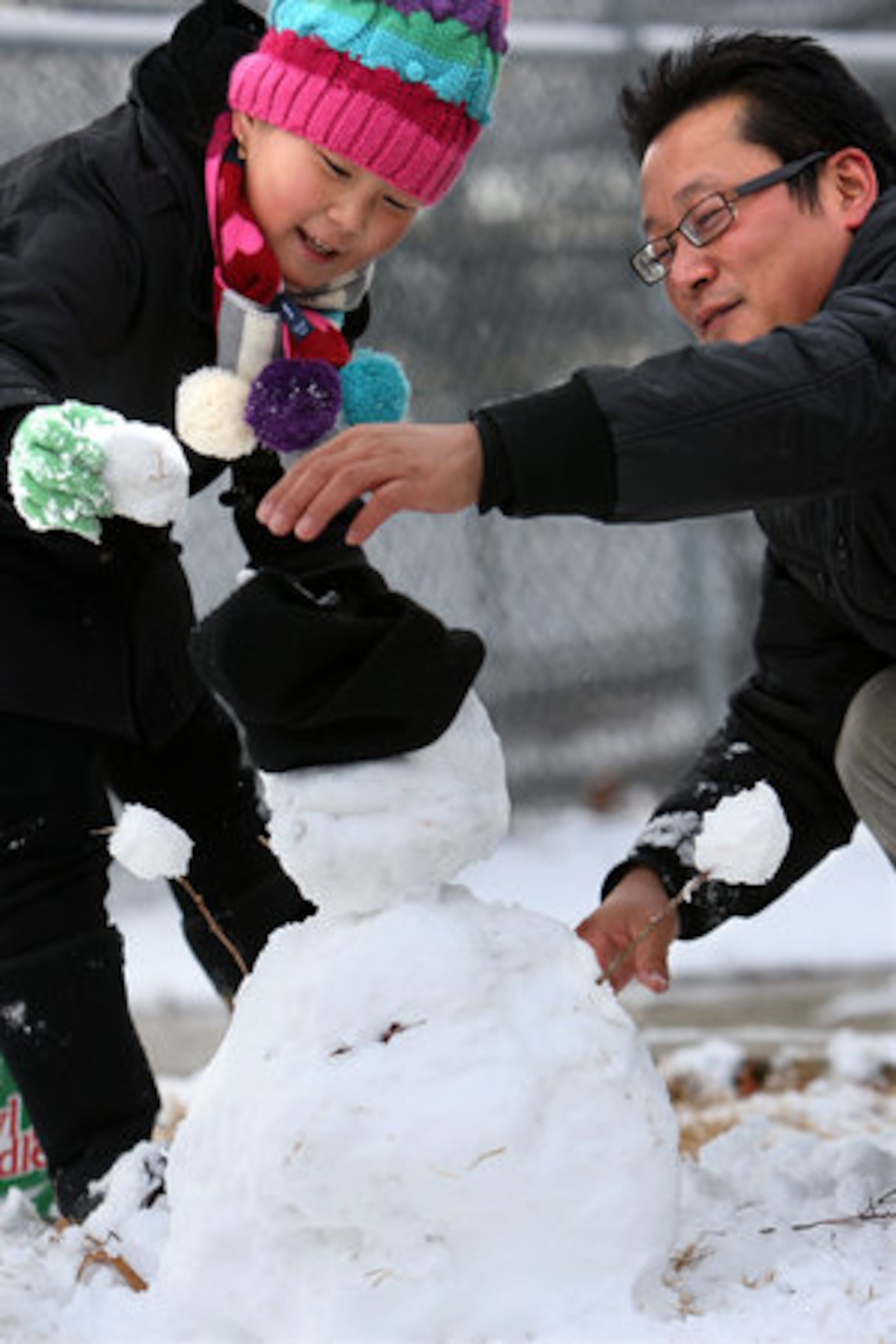 The wintry blast brought snow on Christmas and left behind a blanket of white in the region while Ye Bin Lee, 9, left, and her father Bae Kwon Lee brave the windy morning to built a snowman at Shorty Howell Park Sunday, Dec. 26, 2010
