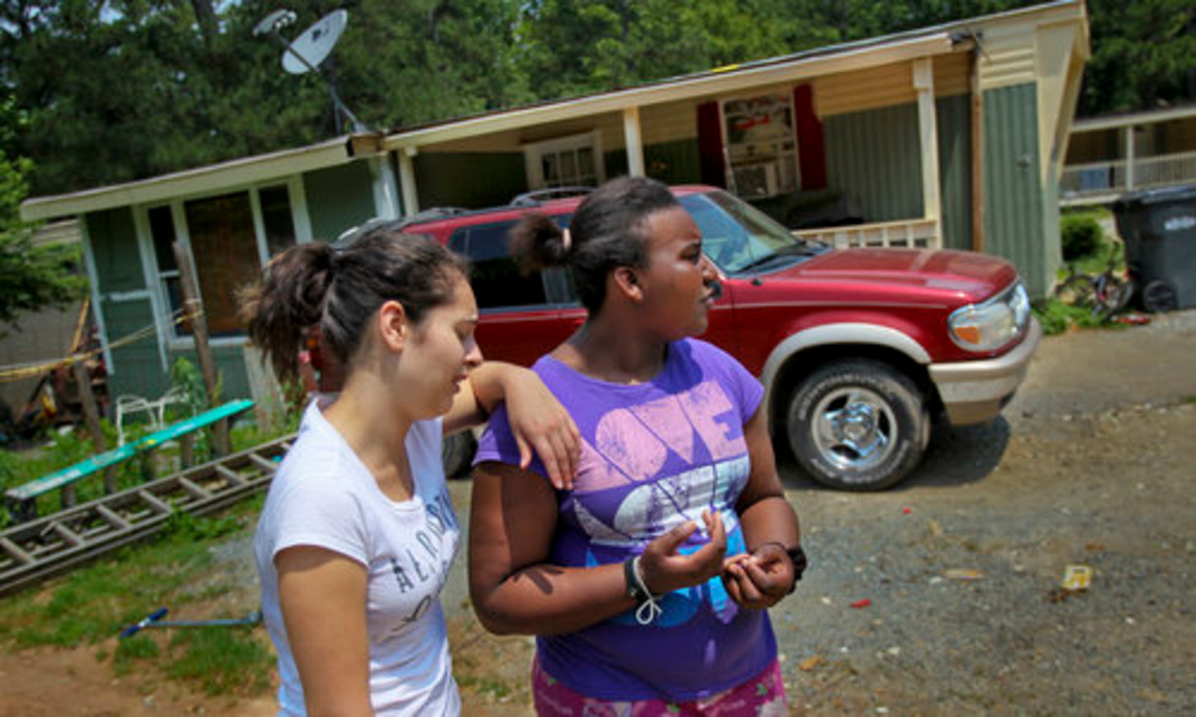 Yasmine Solis, 13, (left) and Emoni Jones, 13, stood in front of the Mondragon family home Friday, where they say their good friend, Javier Mondragon was shot to death by his brother.