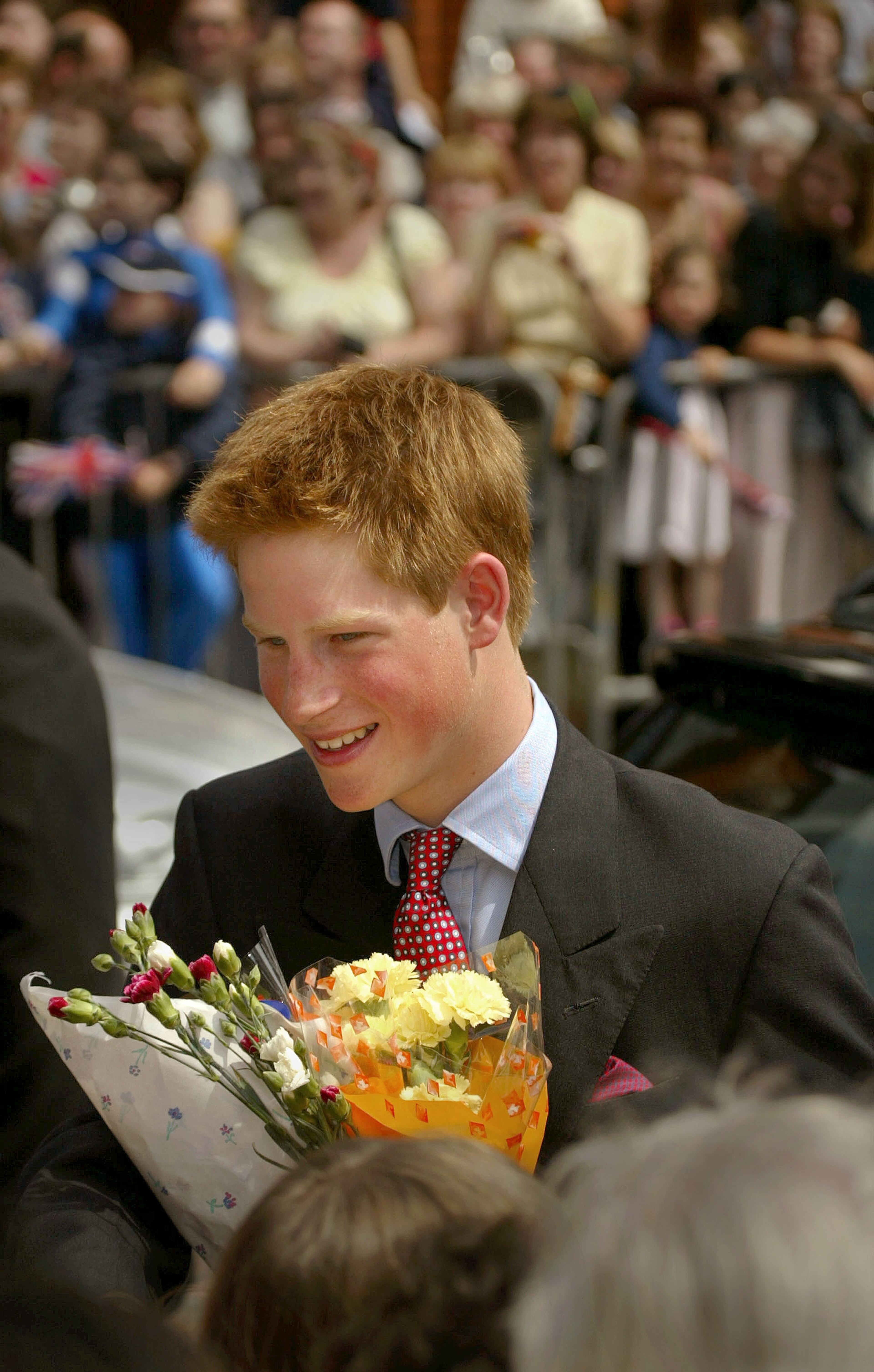 Prince Harry receives flowers from well-wishers June 2, 2002, after a church service at St Mary's Church in Swansea, Wales.
