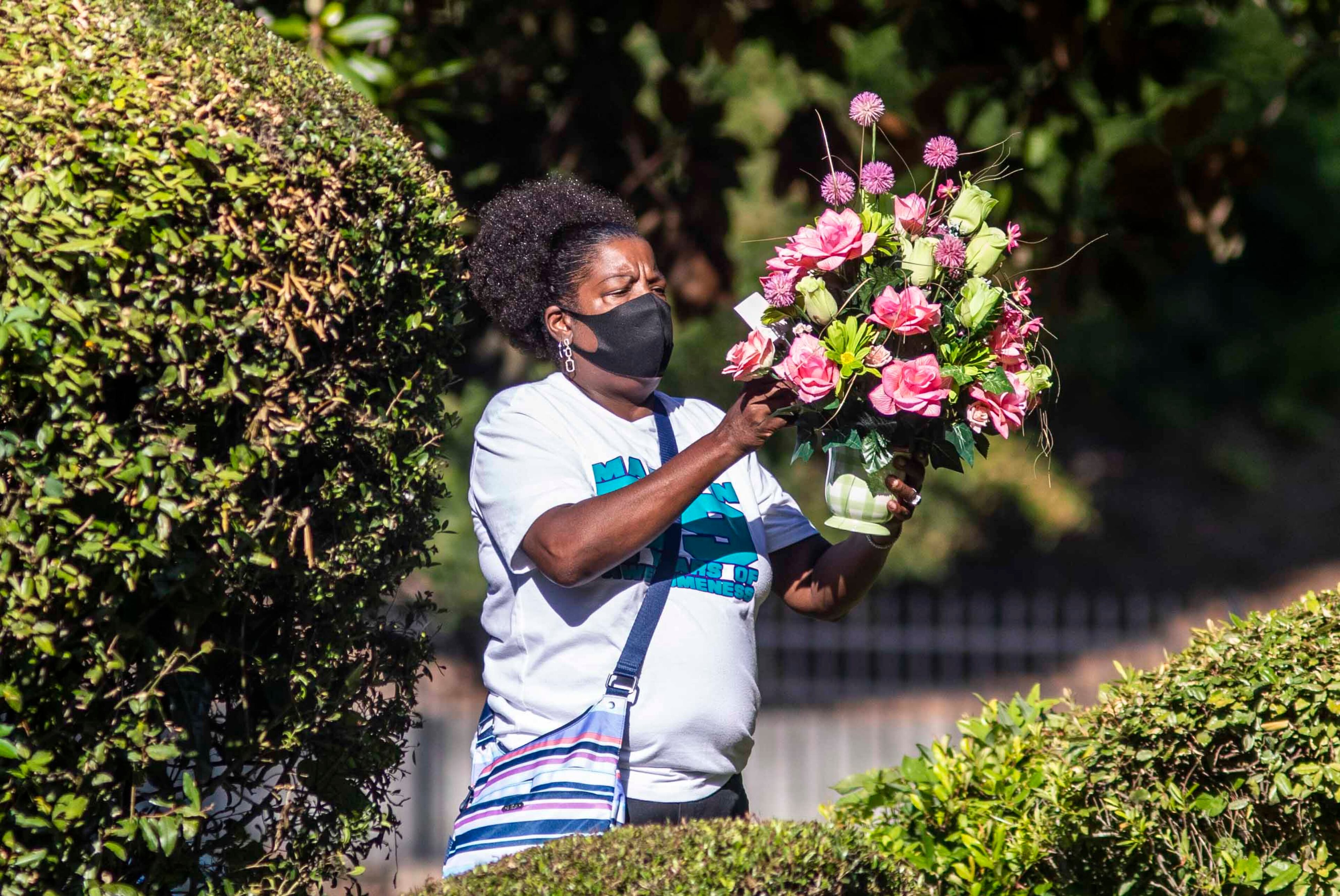 07/14/2020 - Atlanta, Georgia - A woman carries a floral bouquet into Murray Brothers Funeral Home during the public viewing of Secoriea Turner in Atlanta, Tuesday, July 14, 2020. (ALYSSA POINTER / ALYSSA.POINTER@AJC.COM)