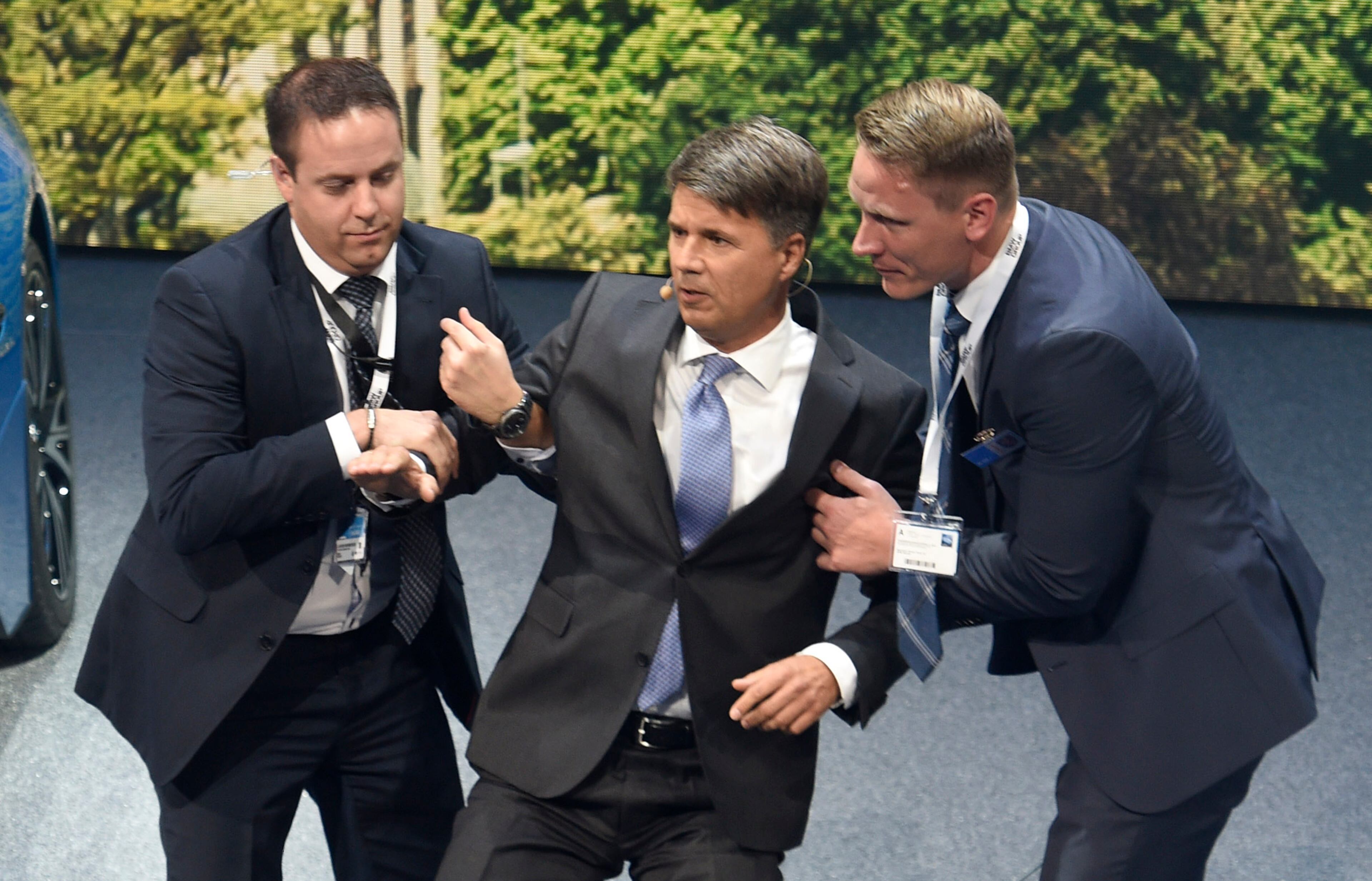 BMW CEO Harald Krueger gets support after collapsing during the BMW presentation on the first press day of the Frankfurt Auto Show IAA in Frankfurt, Germany, Tuesday, Sept. 15, 2015. The car show runs through Sept. 27. (AP Photo/Jens Meyer)