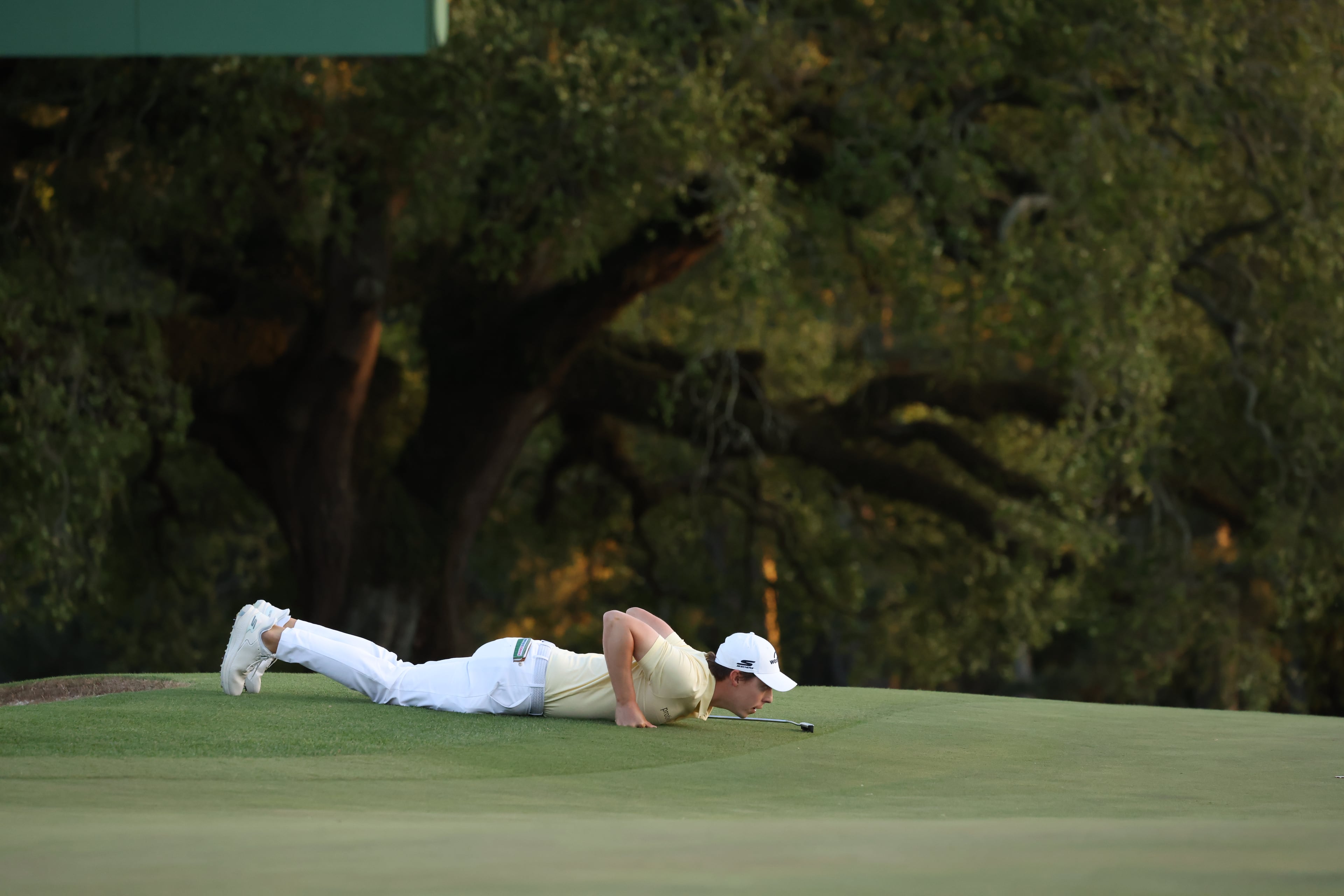 Matt Fitzpatrick lays on the ground to get a better perspective before his putt on 18th hole during second round of the 2024 Masters Tournament at Augusta National Golf Club, Friday, April 12, 2024, in Augusta, Ga. Jason Getz / Jason.Getz@ajc.com)