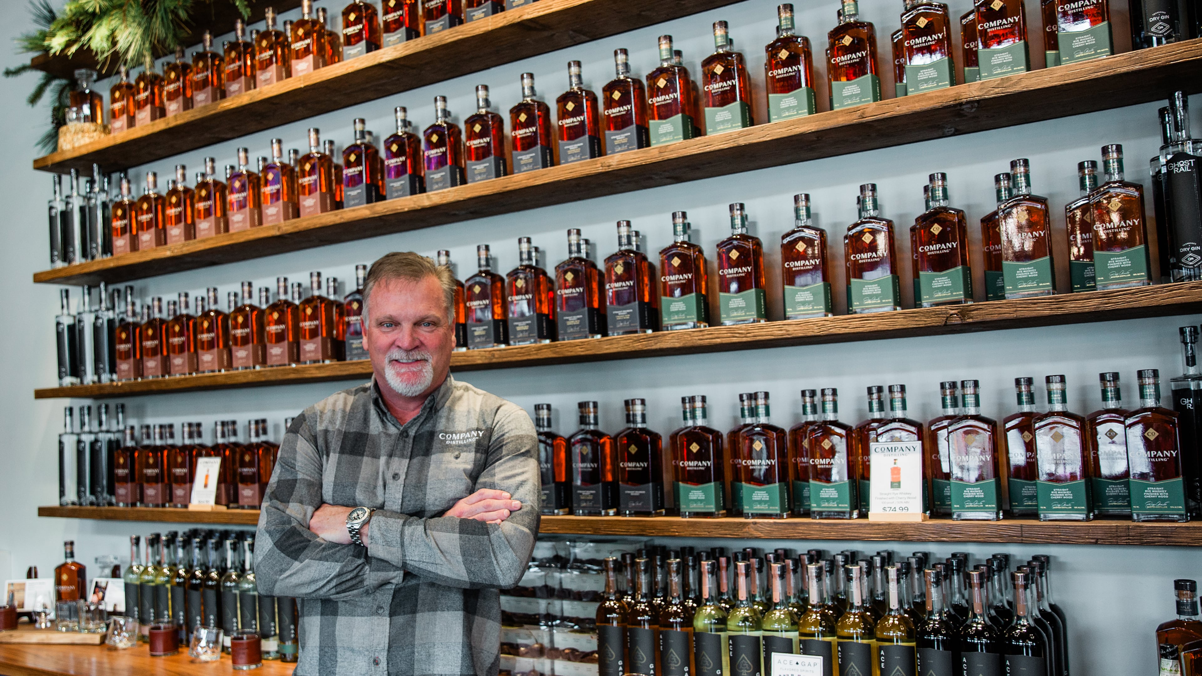 Jeff Arnett stands among bottles of Company Distilling whiskey, the brand he helped build as part of his second act in the spirits industry. (Courtesy of Leonard Garrison)