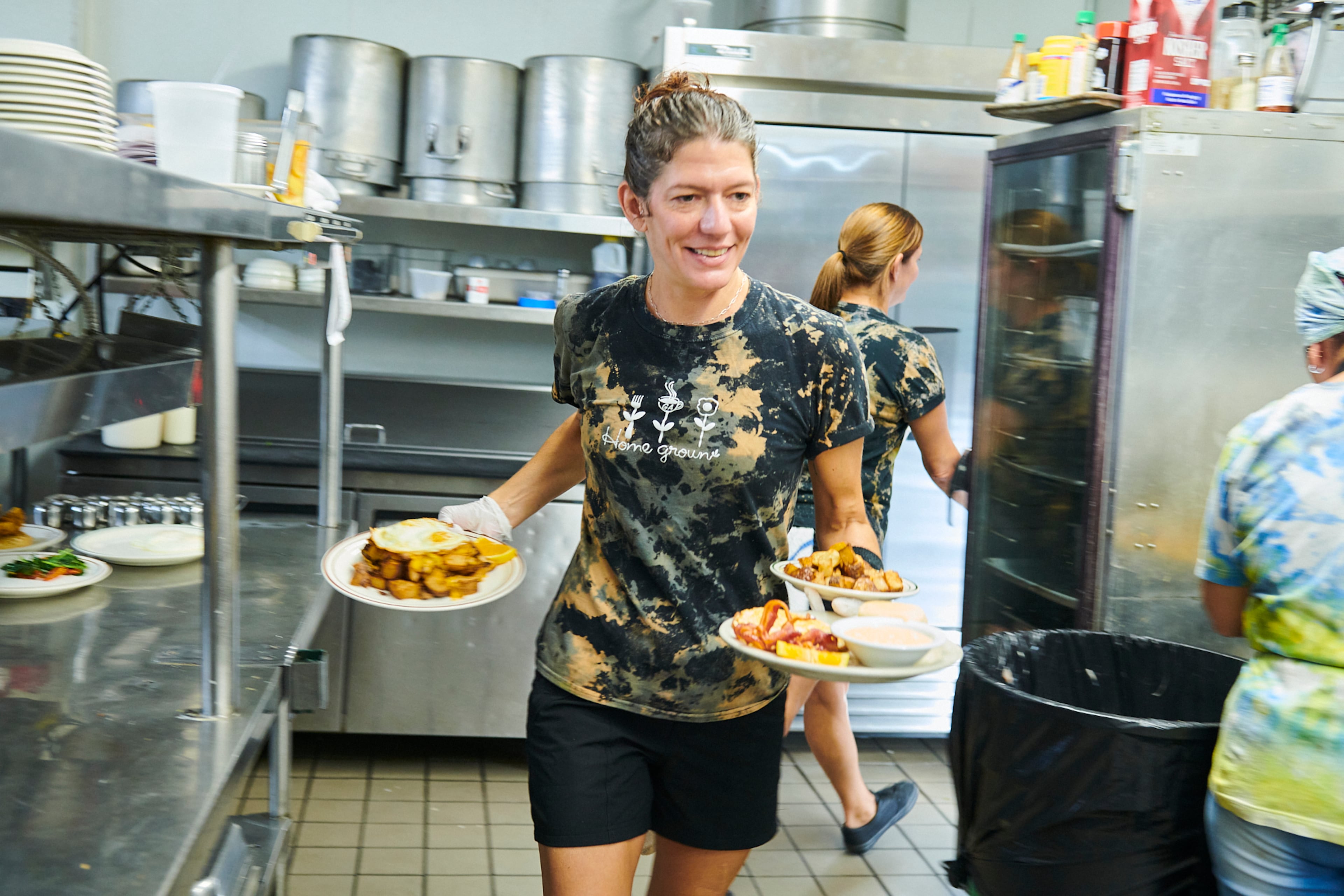 Lisa Spooner carries dishes from the kitchen to waiting customers at Home Grown in Atlanta's Reynoldstown area. (Greg Rannells for The Atlanta Journal-Constitution)