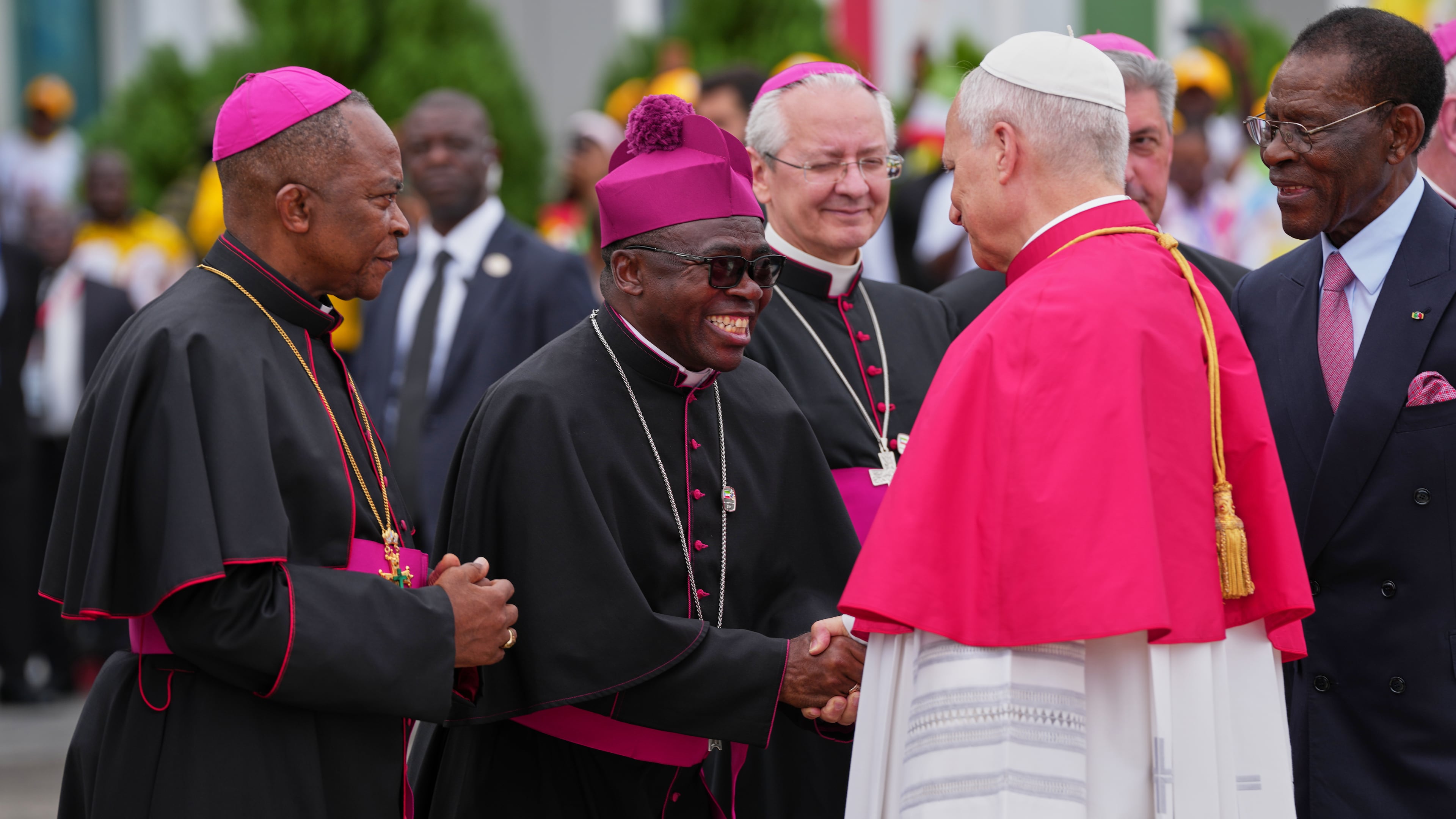 Pope Leo XIV, flanked by Equatorial Guinea's President Teodoro Obiang Nguema Mbasogo, right, is welcomed by Archbishop Juan Nsue Edjang Mayé, left, and Juan Domingo-Beka Esono Ayang upon his arrival at Malabo International Airport in Malabo, Equatorial Guinea, Tuesday, April 21, 2026. (AP Photo/Misper Apawu)