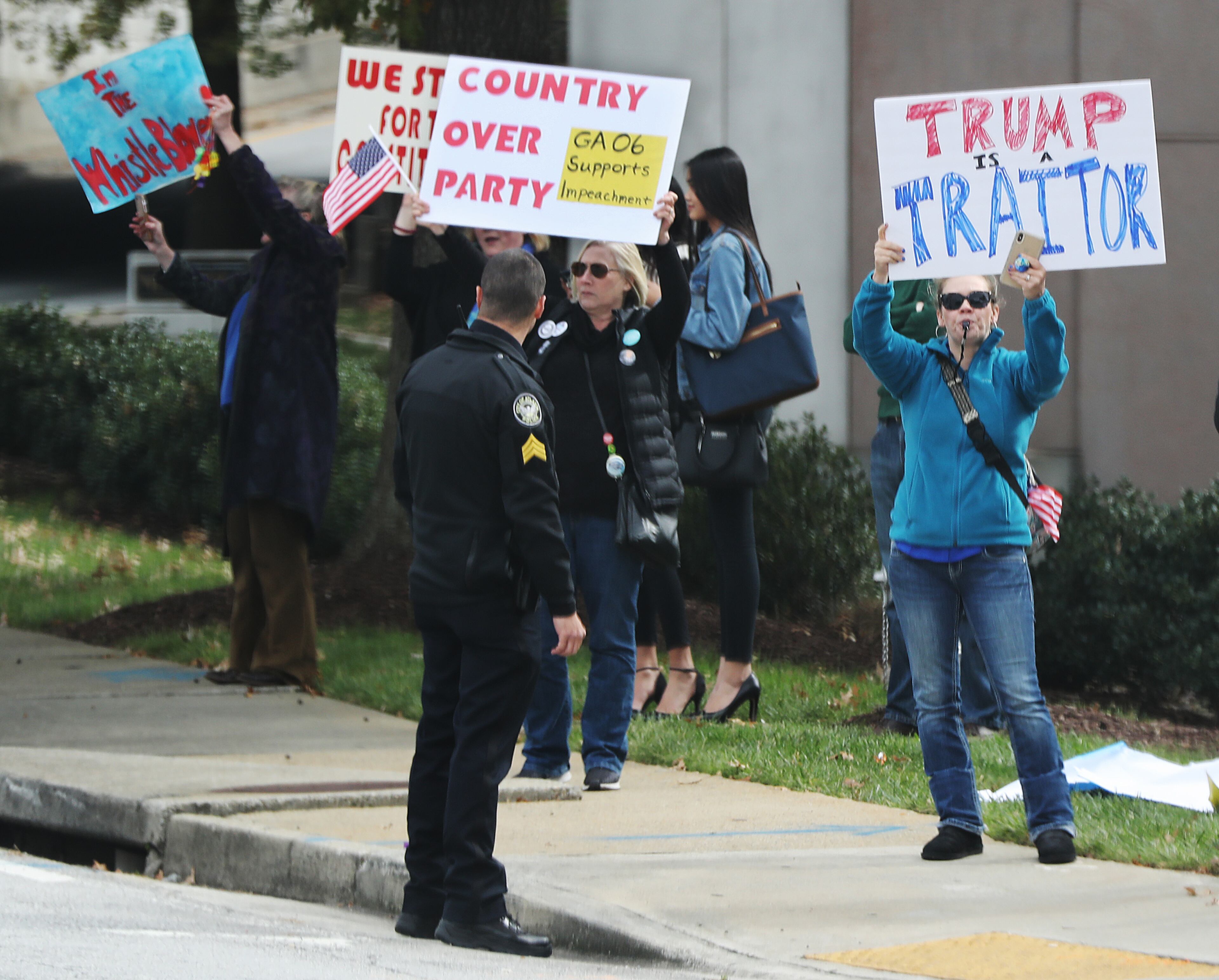 November 8, 2019 Atlanta: Protesters stand on the sidewalk as President Donald Trump arrives at the Ritz-Carlton in Buckhead for a fundraiser on Friday, November 8, 2019, in Atlanta. Curtis Compton/ccompton@ajc.com