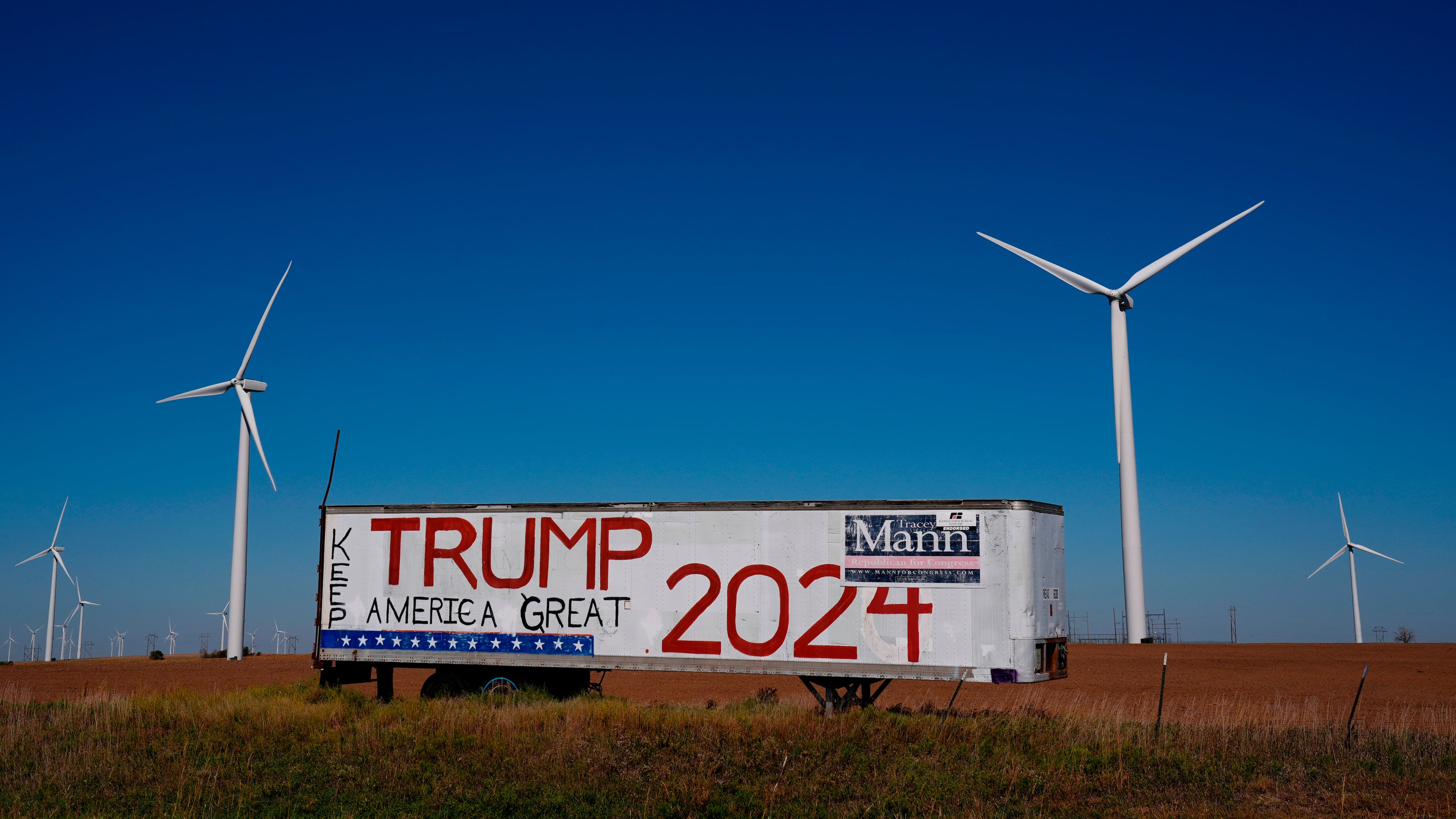 FILE - A trailer with a sign supporting President Donald Trump stands adjacent to the Smoky Hills wind farm, Sept. 30, 2024, near Ellsworth, Kan. (AP Photo/Charlie Riedel, file)
