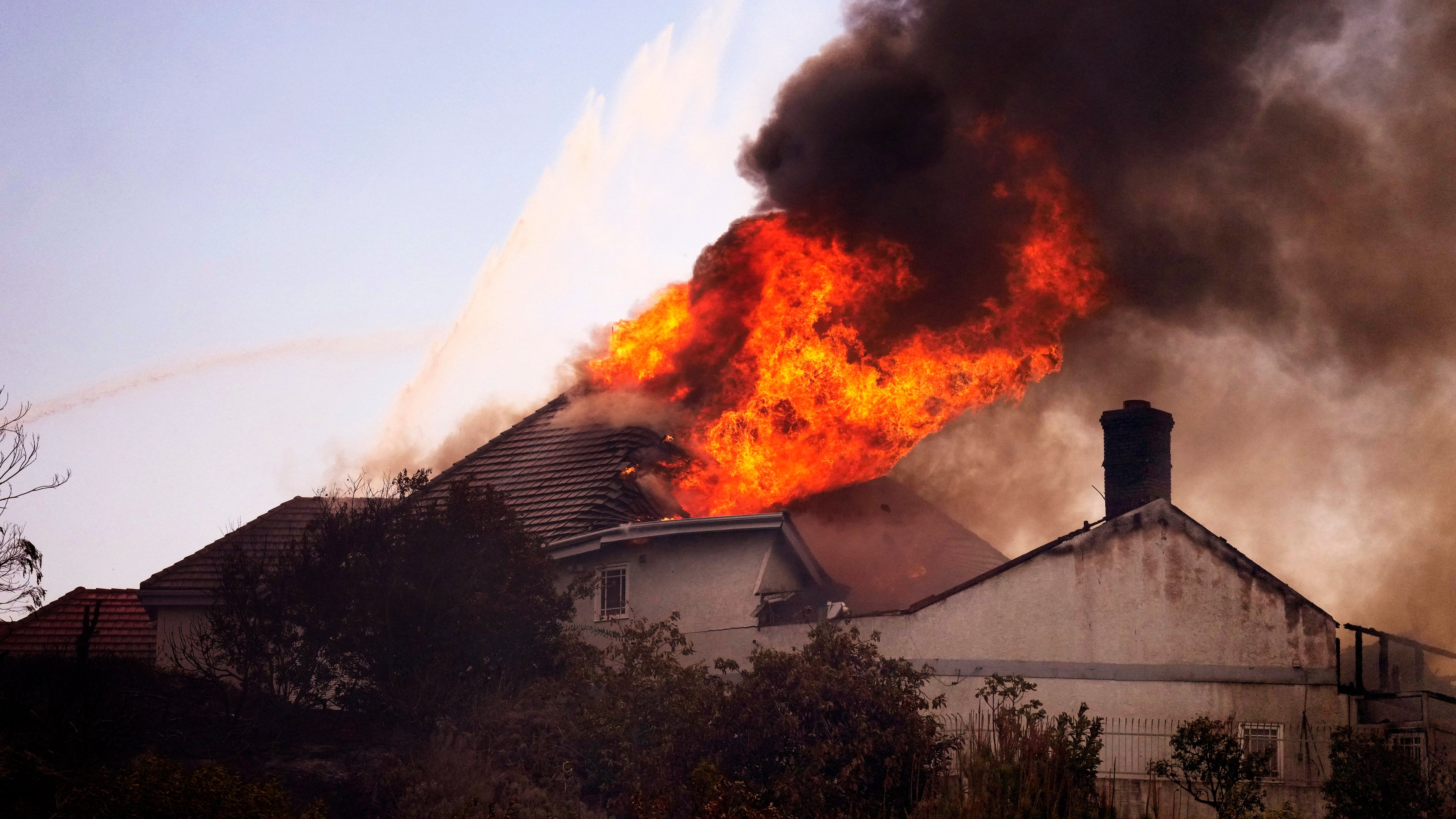 A roof engulfed in flames is seen during the Norte Fire on Friday, Oct. 16, 2026, in San Juan Capistrano, Calif. (AP Photo/Jae C. Hong)