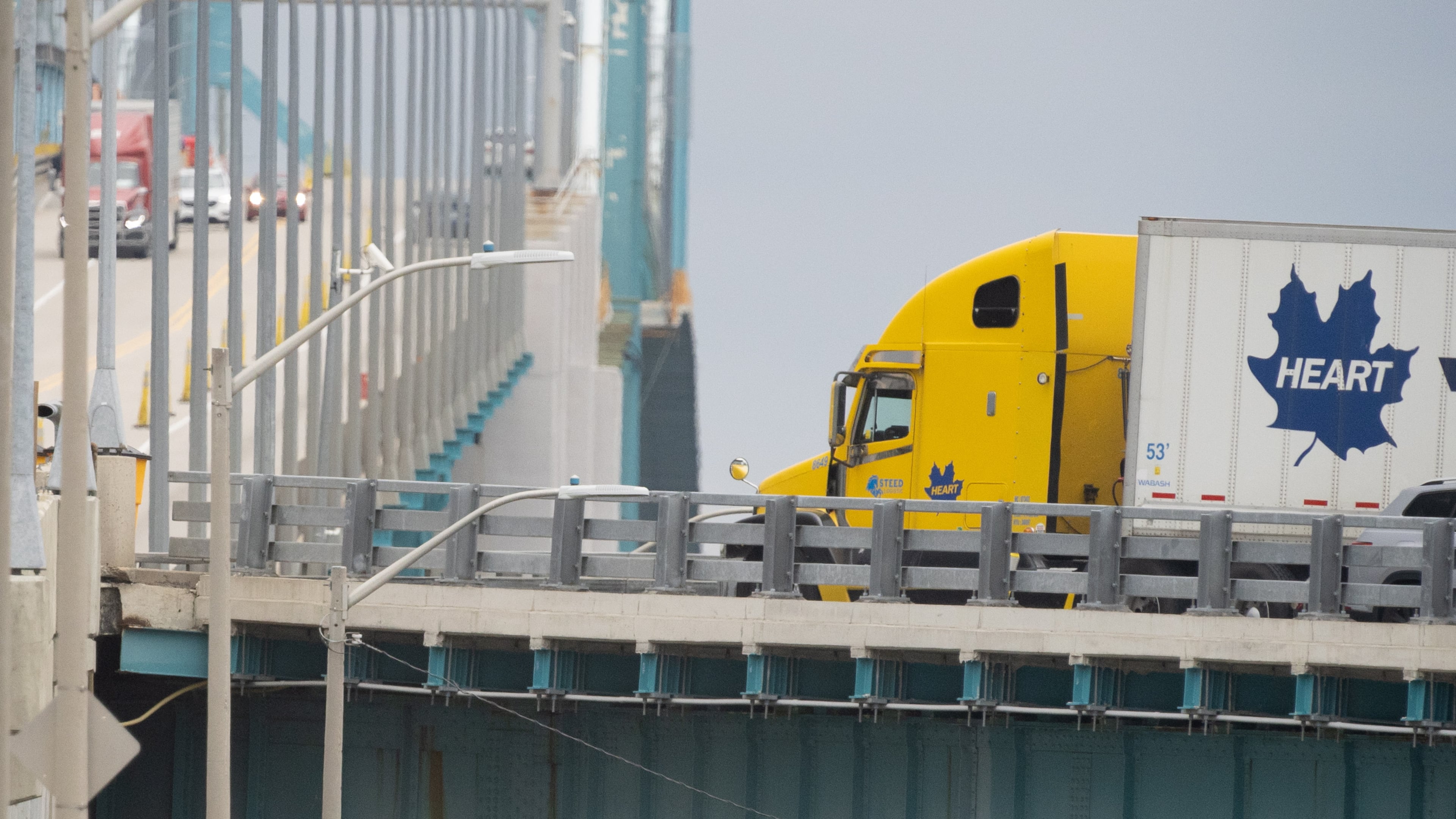 Transport trucks cross the Ambassador Bridge into the United States of America, in Windsor, Ontario, Canada, Saturday, Aug. 22, 2026. (Dax Melmer/The Canadian Press via AP)