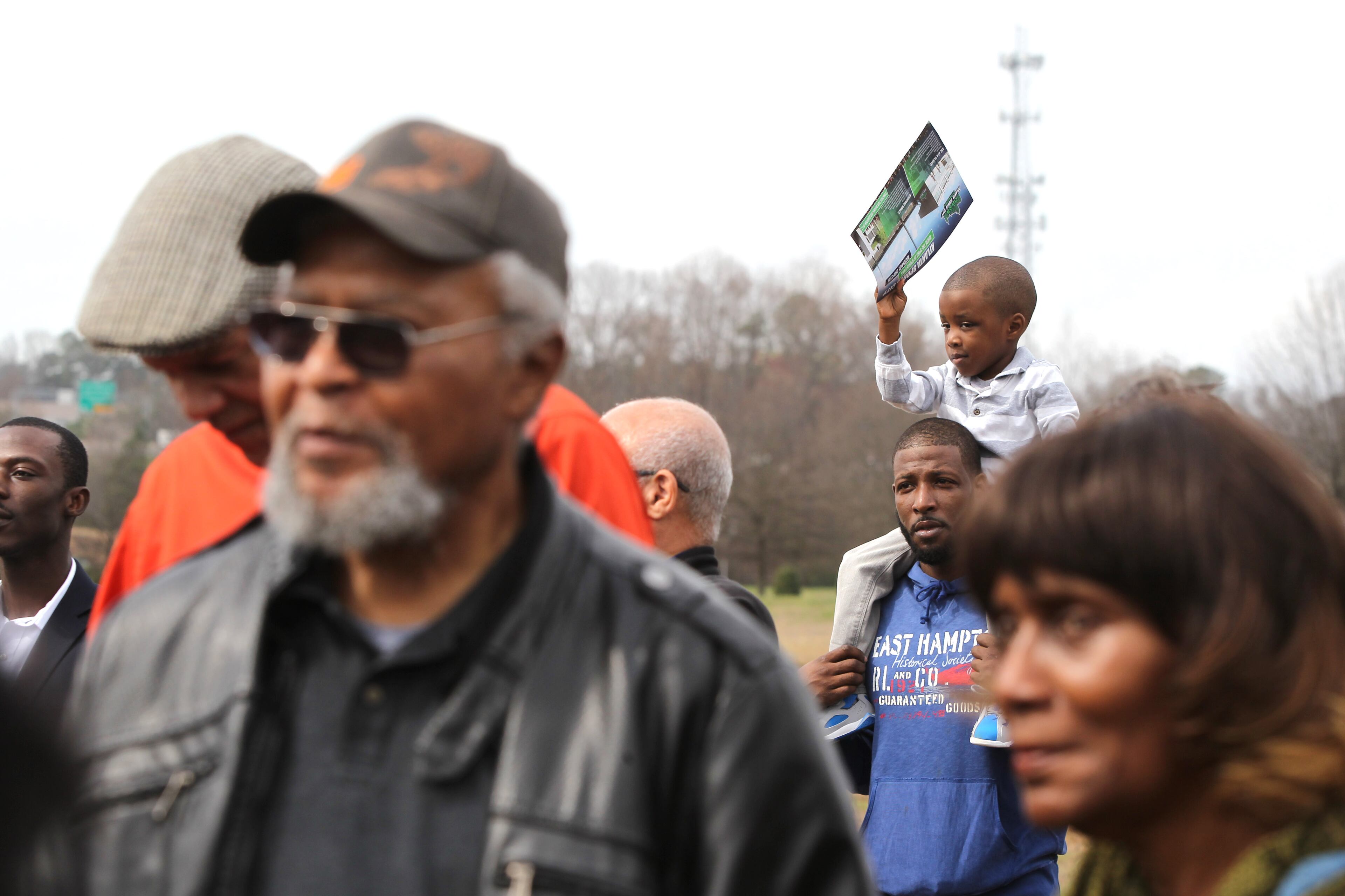 February 22, 2017, Atlanta, Georgia - Devon Thompson holds his son, Ajani, up on his shoulders where Ajani waves about one of the maps passed out during the presentation at the unveiling of the Atlanta Sports City sports complex site in Stonecrest, Georgia, on Wednesday, February 22, 2017. (HENRY TAYLOR / HENRY.TAYLOR@AJC.COM)