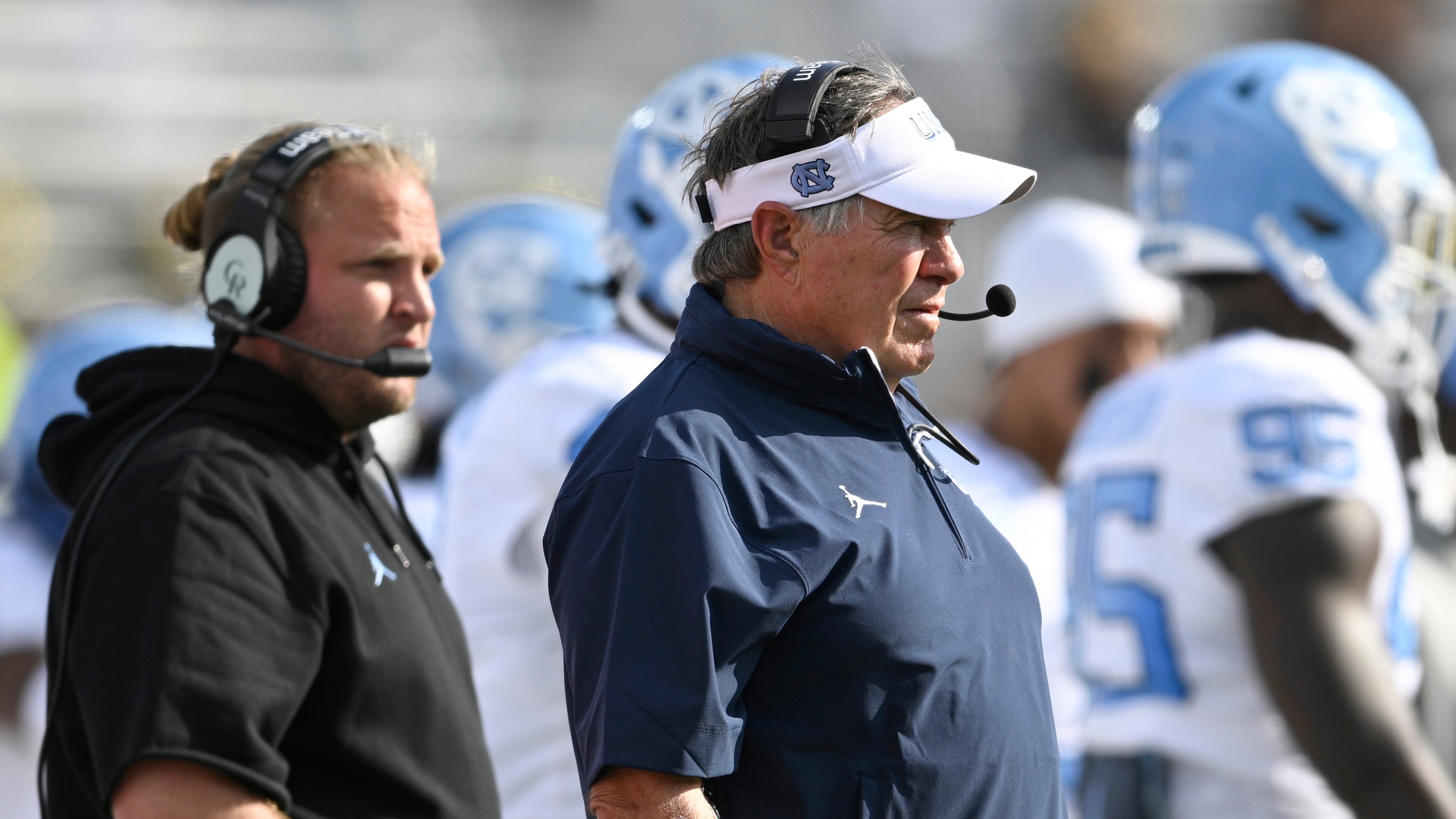 FILE - North Carolina head coach Bill Belichick, center, and defensive coordinator Steve Belichick, left, look on during the first half of an NCAA football game against Central Florida, Saturday, Sept. 20, 2025, in Orlando, Fla. (AP Photo/Phelan M. Ebenhack, File)